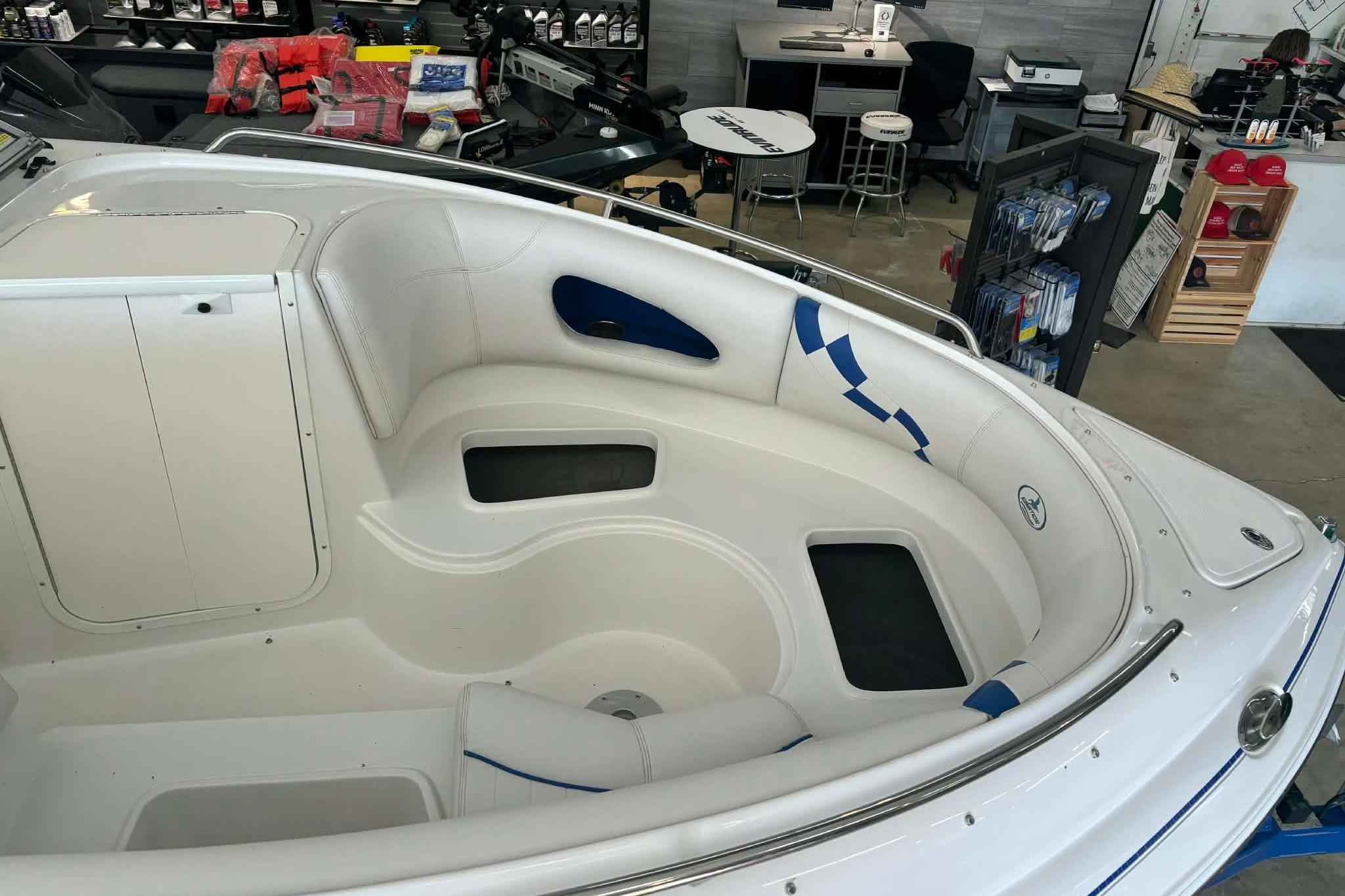 1999 Tide Craft Trophy Angler boat interior with white and blue seating in showroom.
