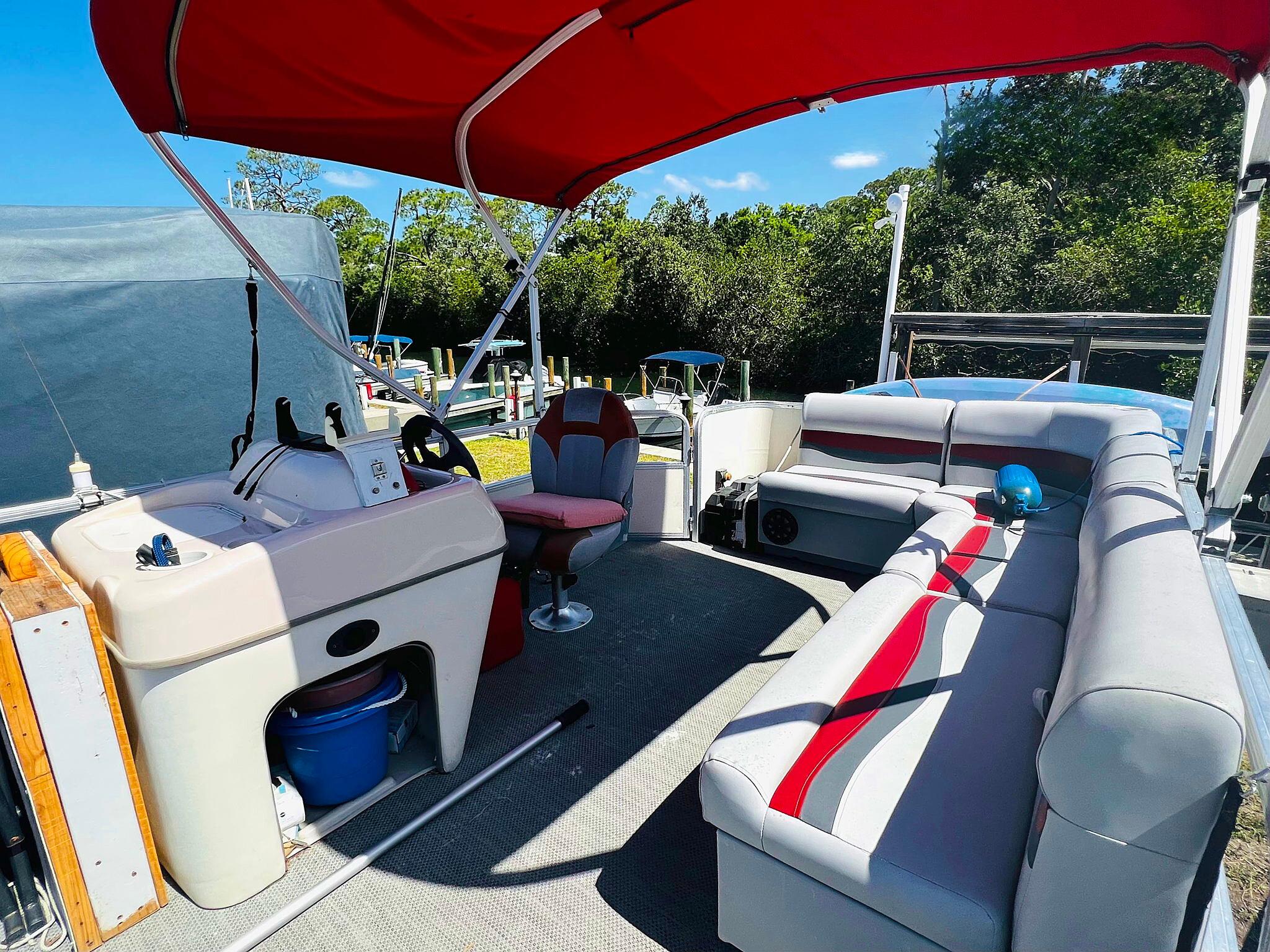 2009 Sun Tracker 200 Party Barge Classic with red canopy and spacious seating.