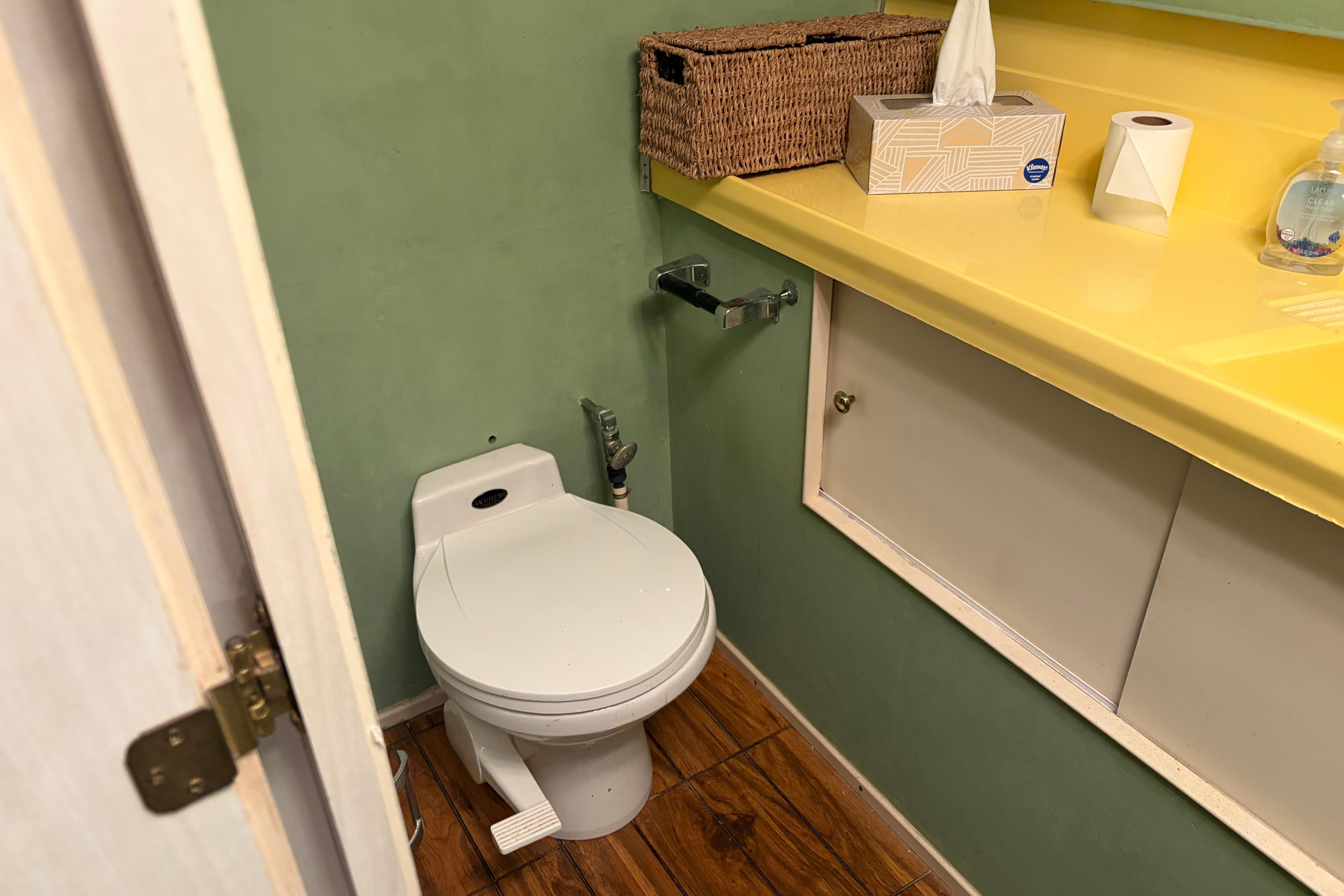 Small bathroom on 1971 Chris-Craft 42 Commander with green walls and yellow countertop.