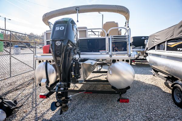 2025 Sun Tracker Bass Buggy 16 DLX pontoon boat with outboard motor in a marina.