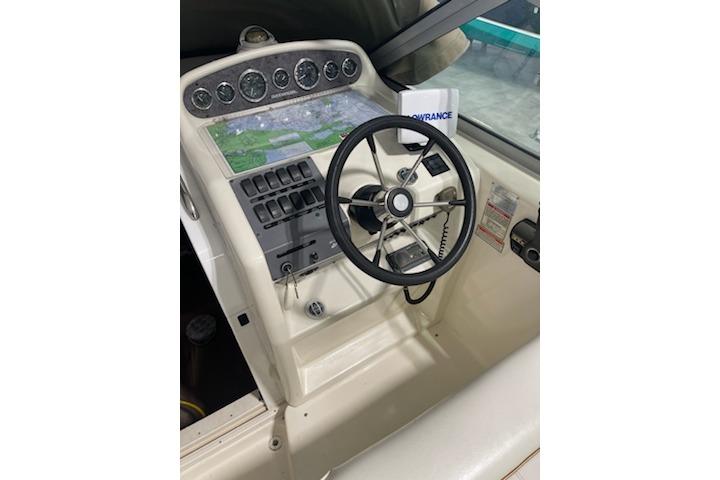 1998 Sea Ray 270 Sundancer helm with steering wheel and navigation controls.