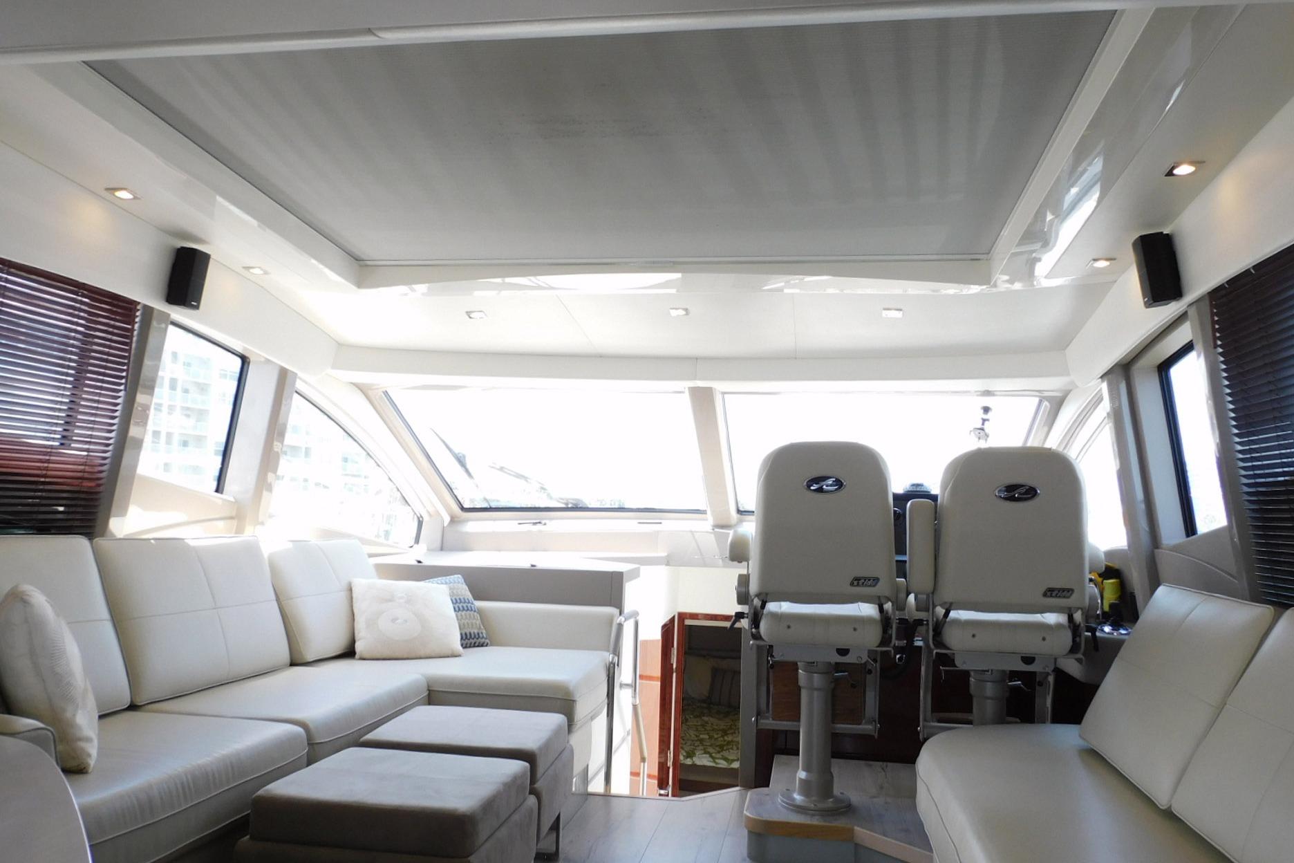 Luxurious interior of a 2019 Sea Ray L550 yacht with plush seating and helm chairs.