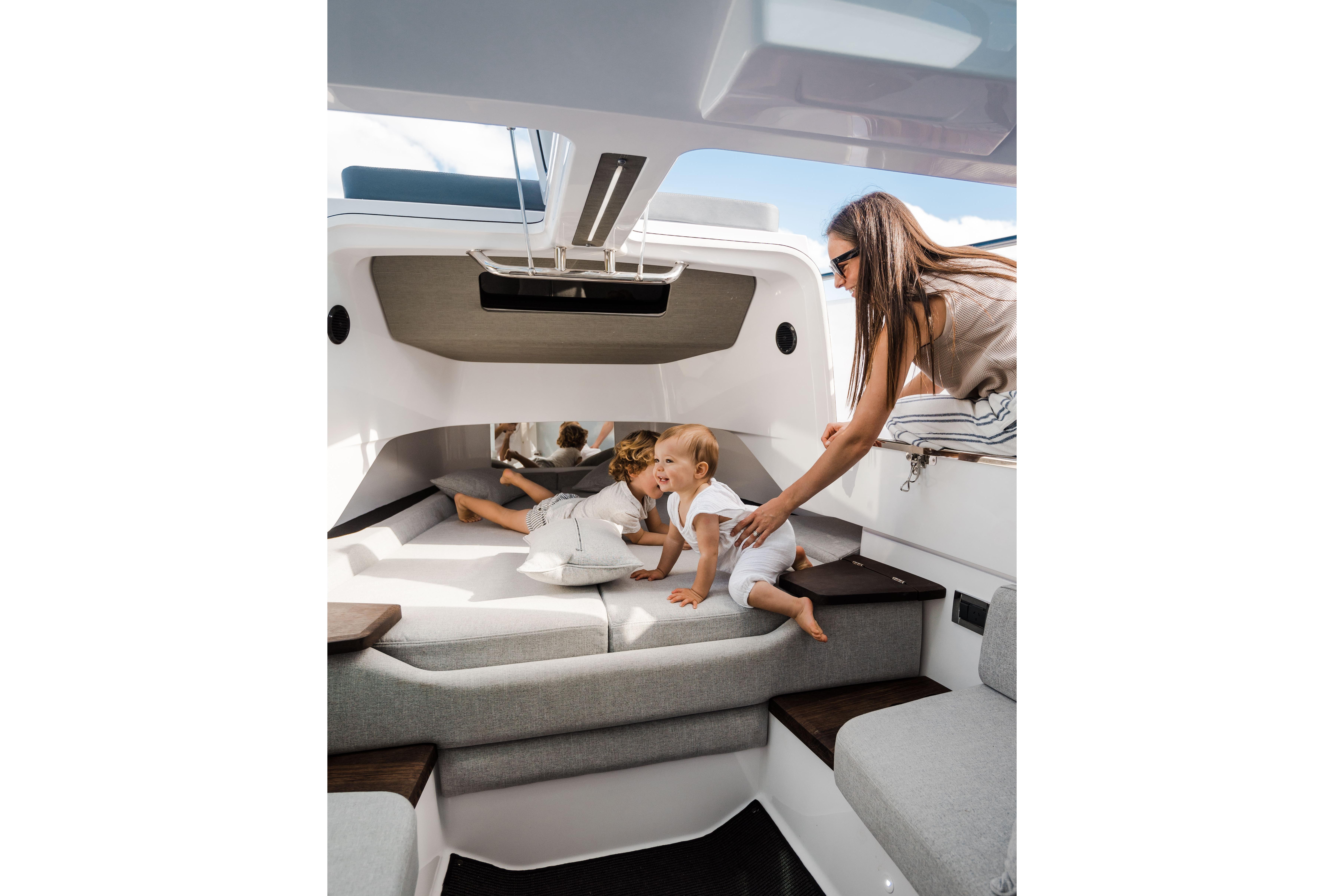 Family enjoying the interior of a 2023 Axopar Sun Top 37 boat.