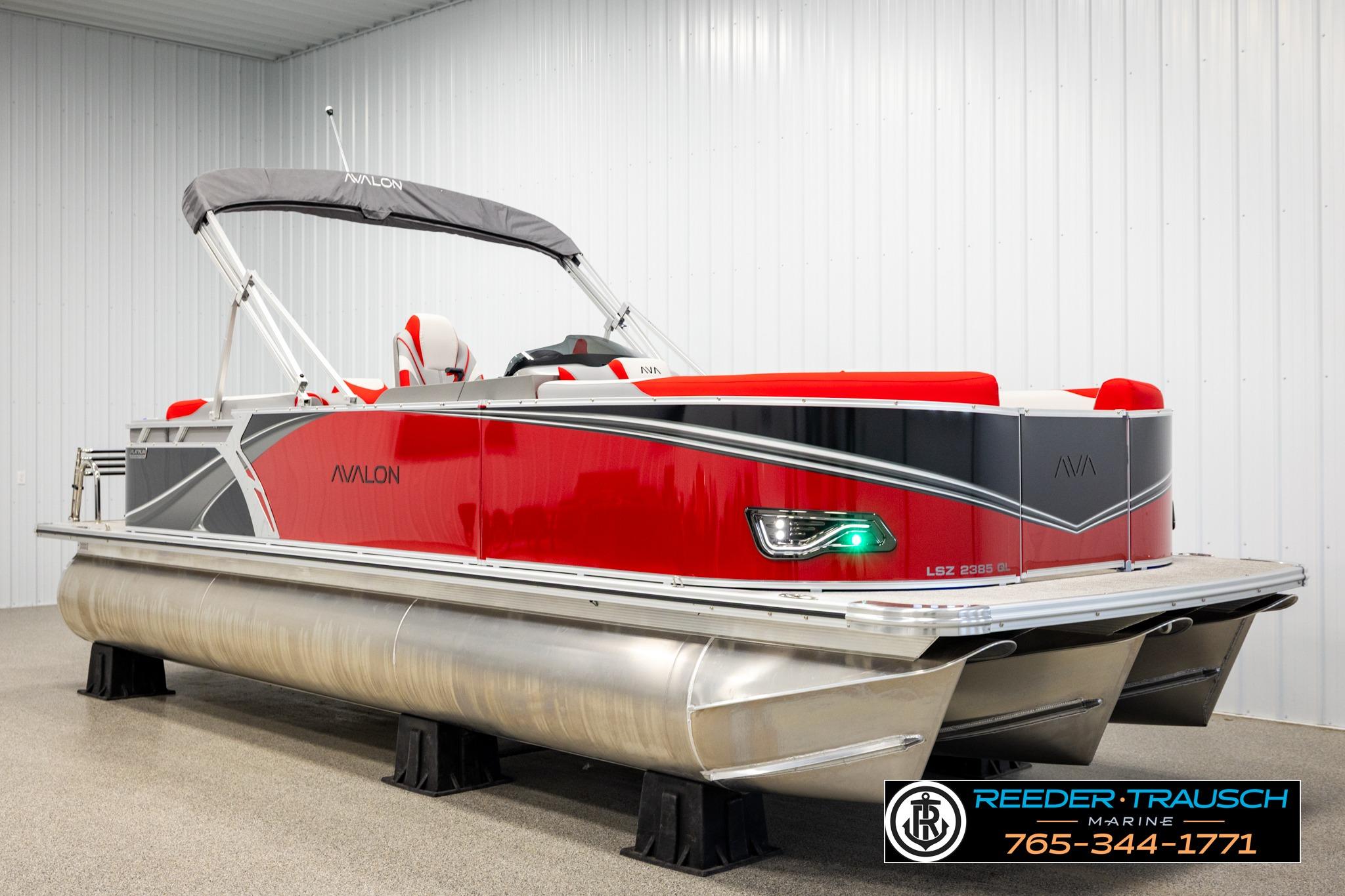 2026 Avalon LSZ QL pontoon boat in showroom, featuring sleek red and gray design.