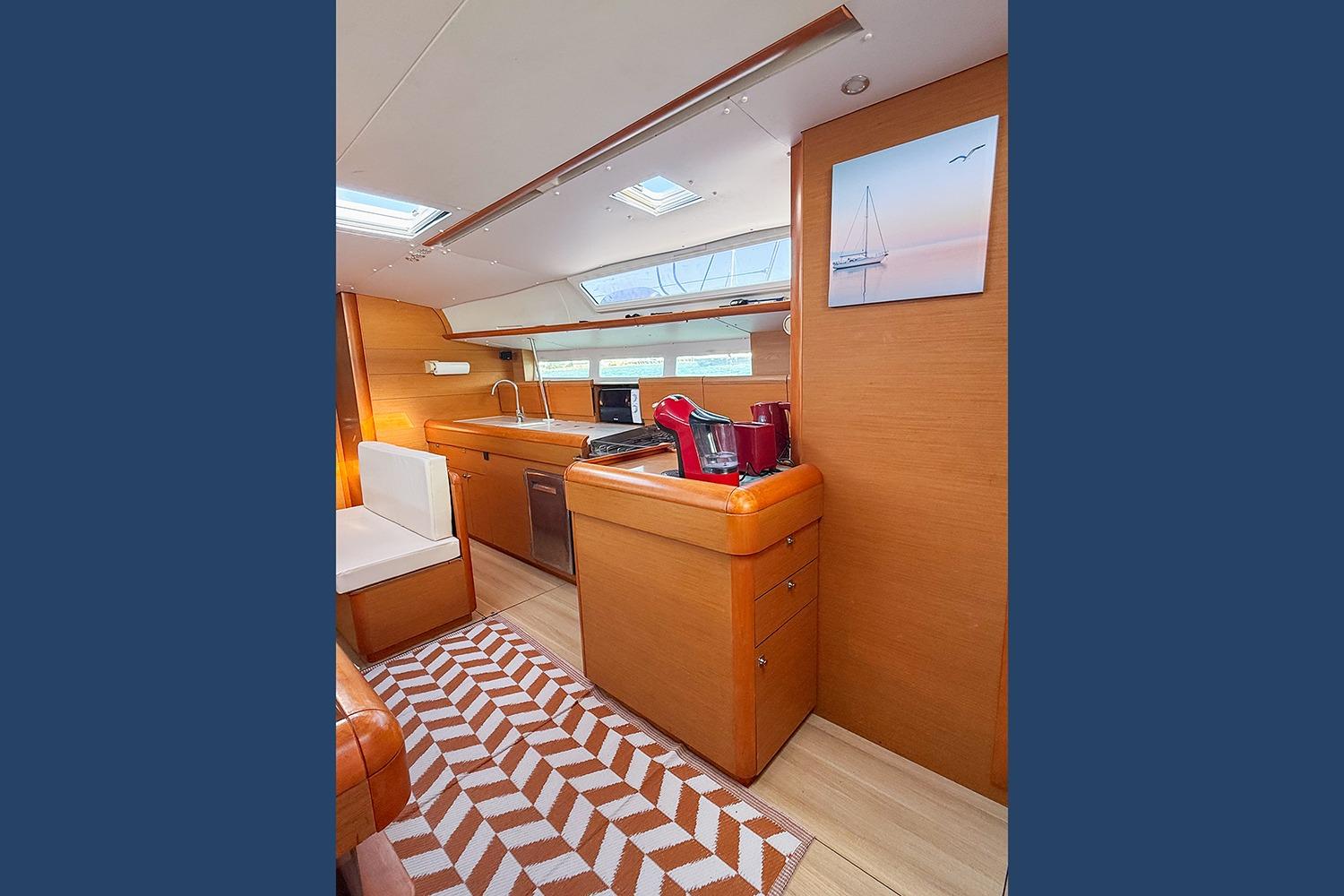 Interior of 2015 Jeanneau Sun Odyssey 509 yacht with modern kitchen and seating area.