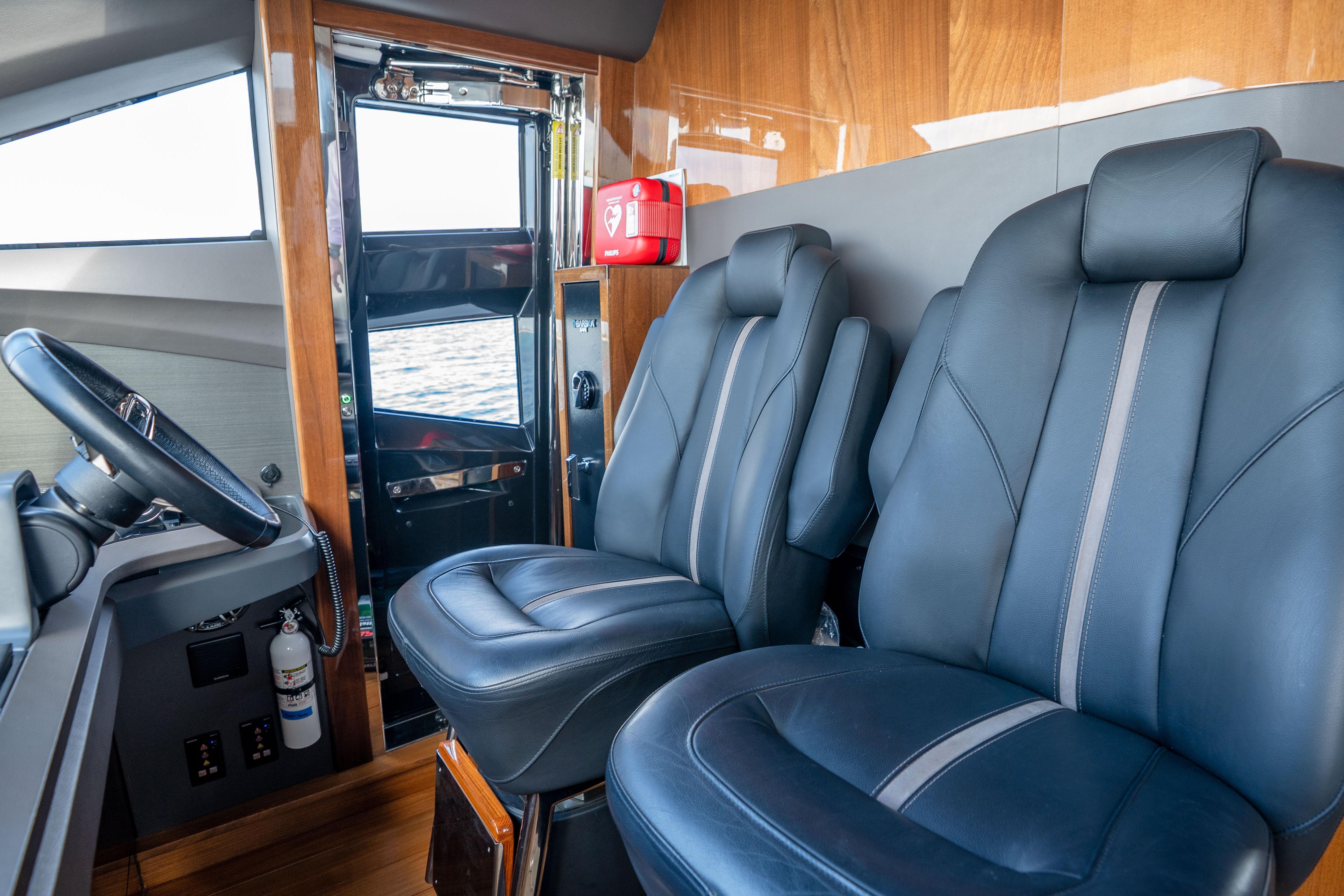 Luxurious interior of 2020 Princess Y85 yacht with leather seats and steering wheel.