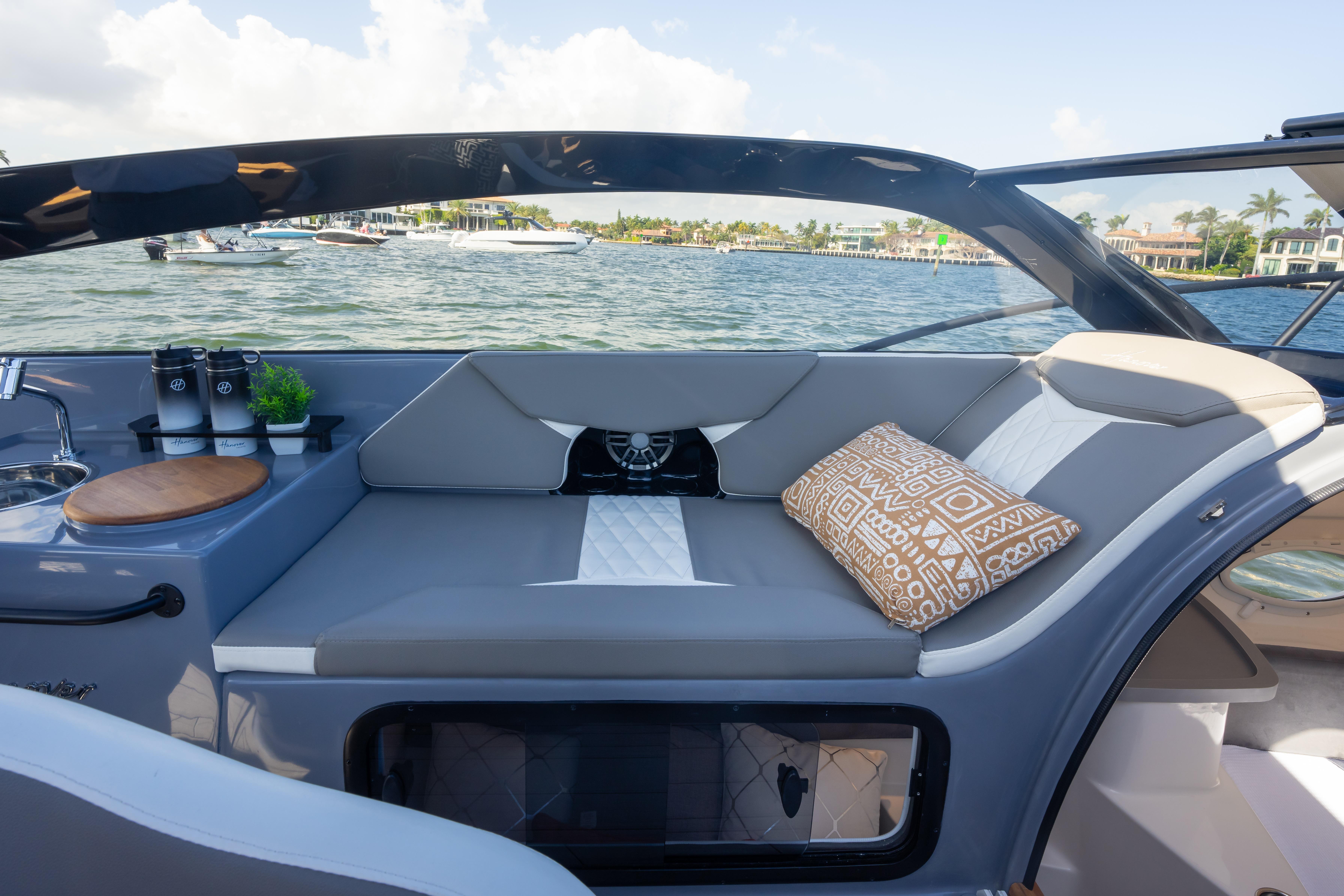 Luxurious seating area on 2026 Hanover 305 boat with scenic waterfront view.