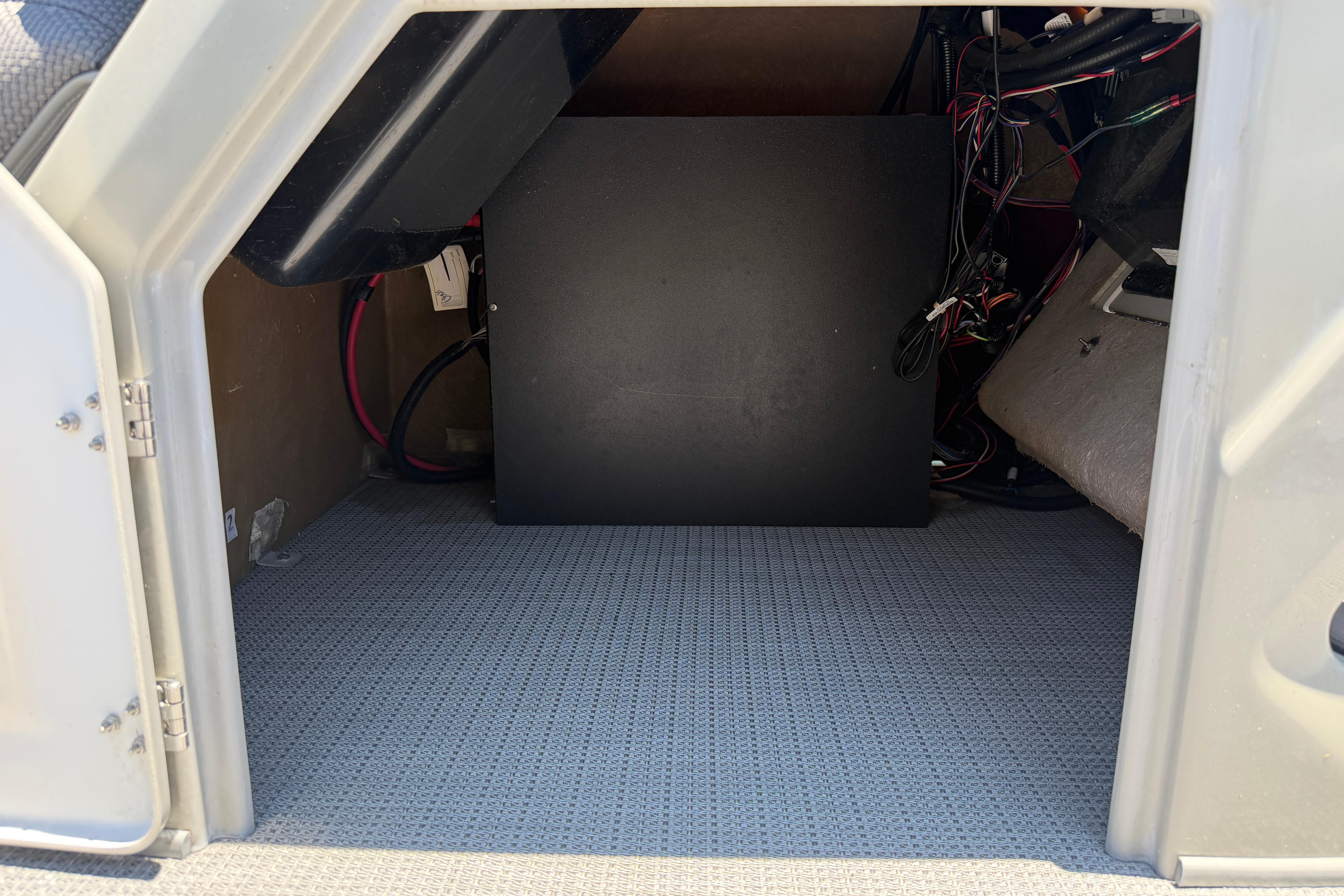 2024 Regency R250DL3 storage compartment with wiring and carpeted floor.