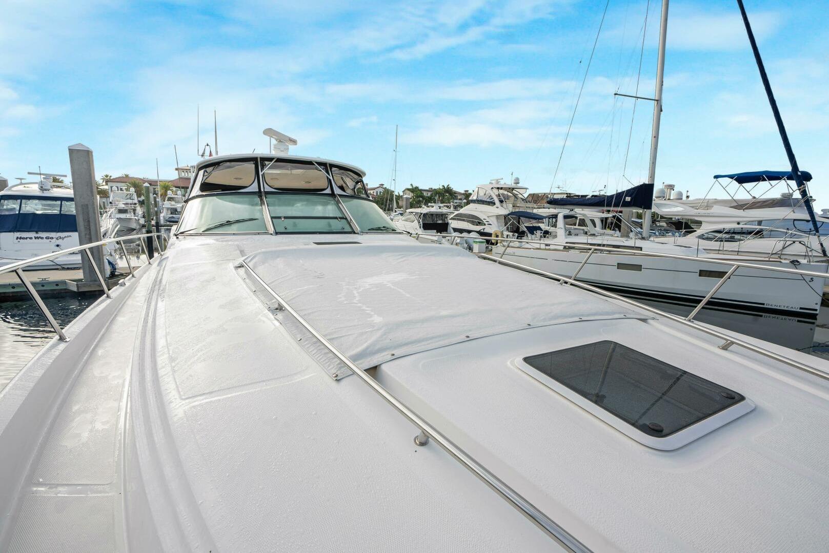 2003 Sea Ray Sundancer 460 yacht docked at marina under clear blue sky.