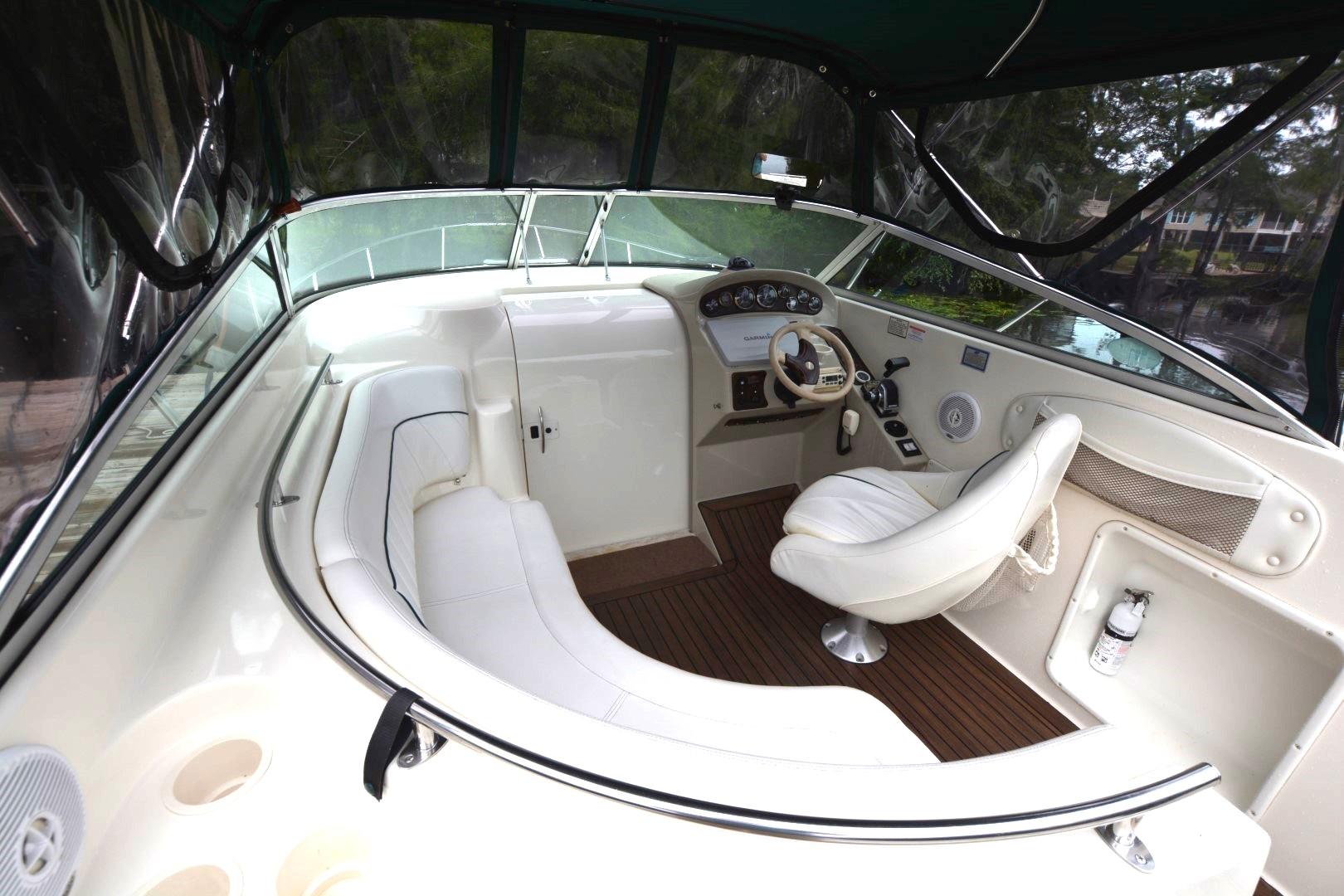 Interior of 1999 Rinker 270 Fiesta Vee boat with white seating and wooden flooring.
