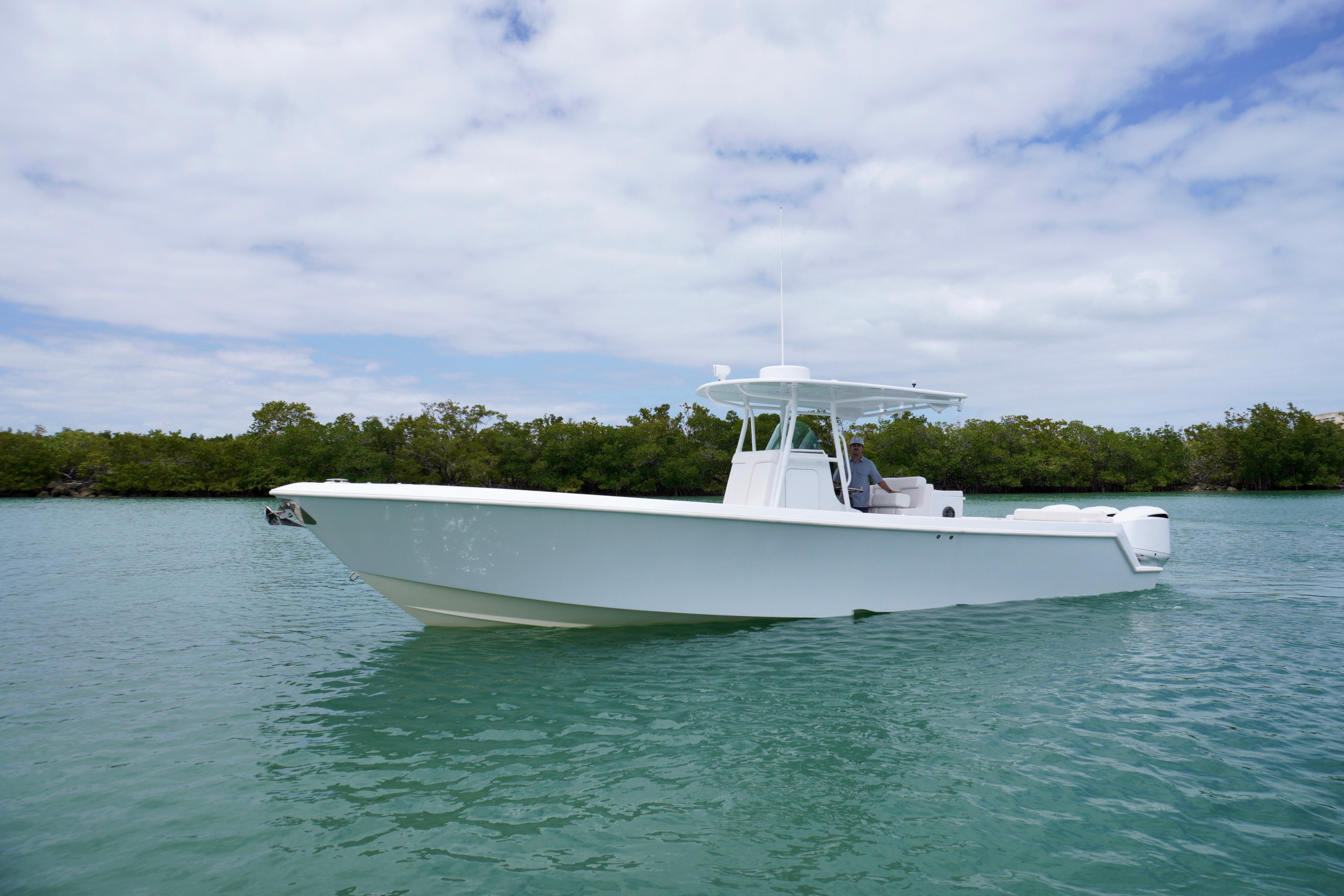 2013 Contender 35 LS boat on calm water with lush greenery background.