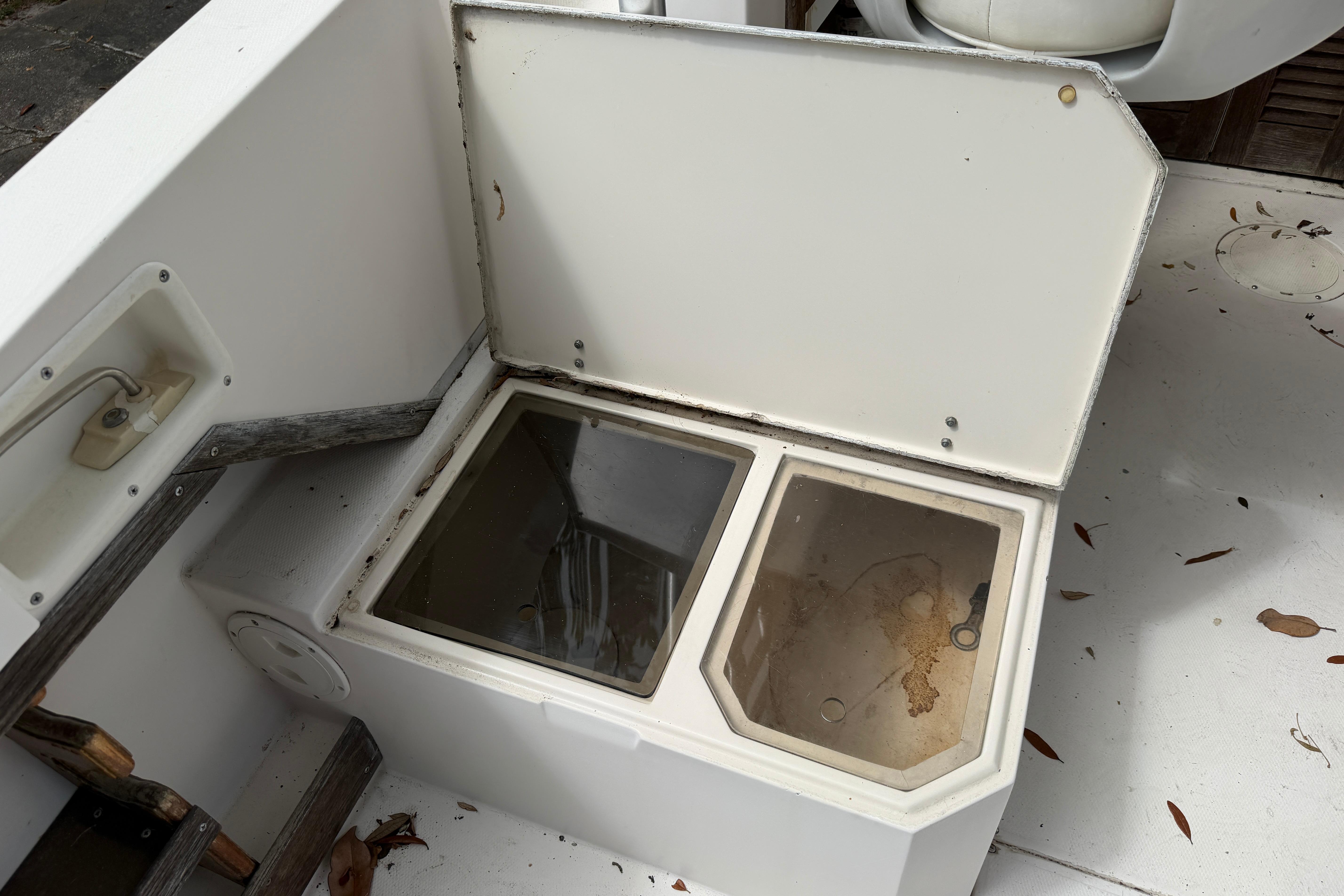 Open storage compartment on 1987 Grady-White Seafarer 226 boat, showing interior details.