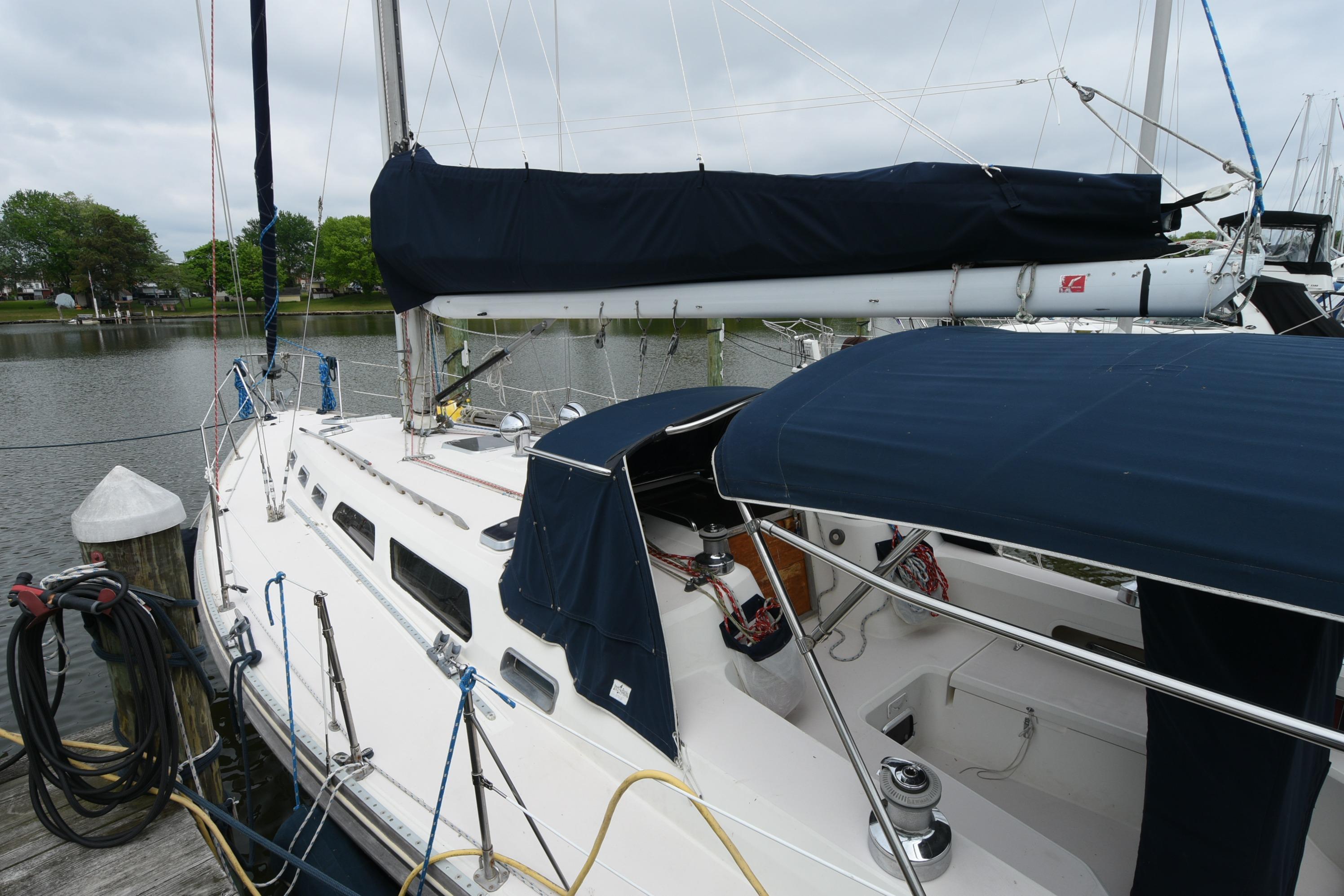 1996 Sabre 402 sailboat docked by a calm waterfront, featuring blue covers.