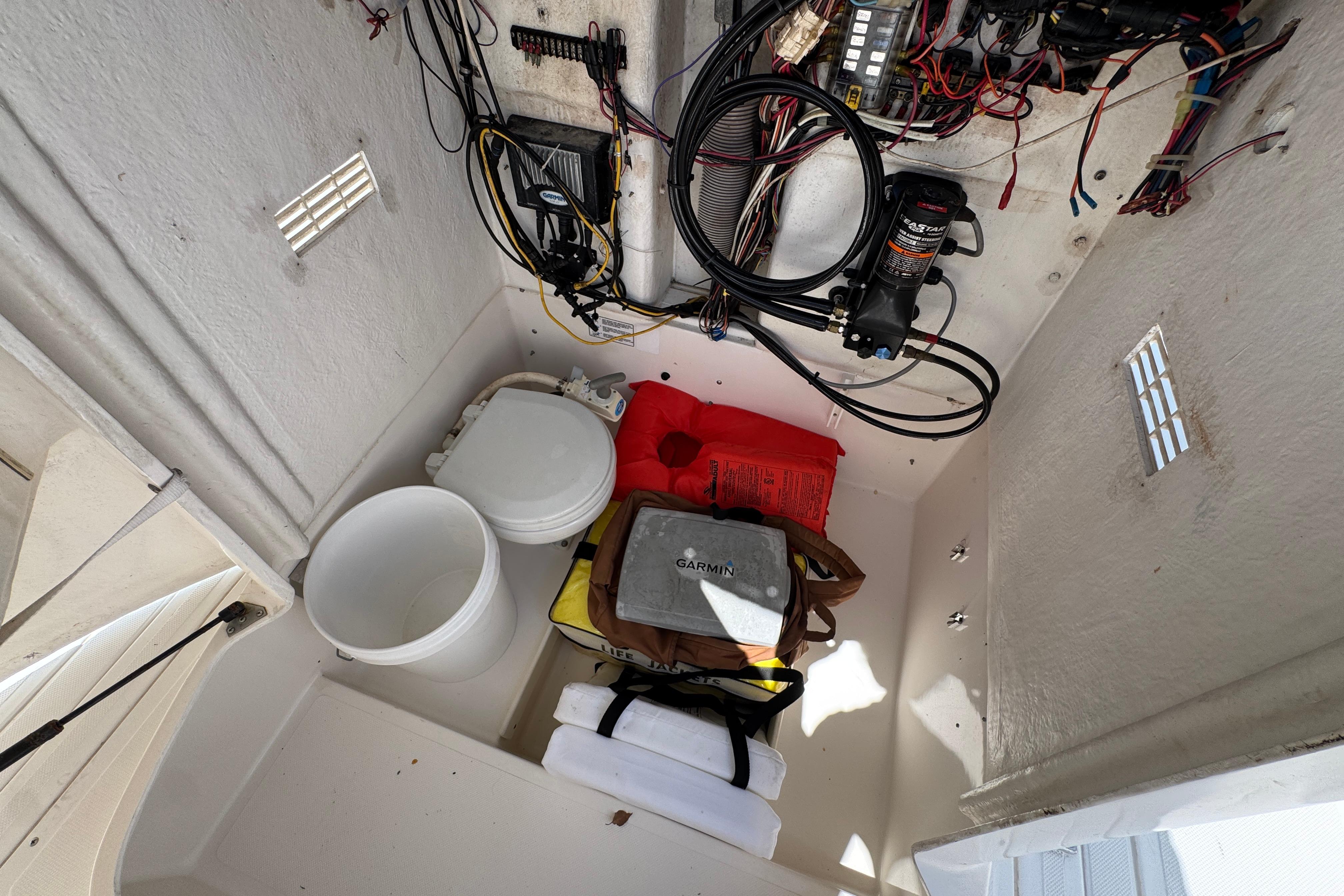 Storage compartment of a 2000 Stamas 250 Tarpon boat with equipment and wiring.