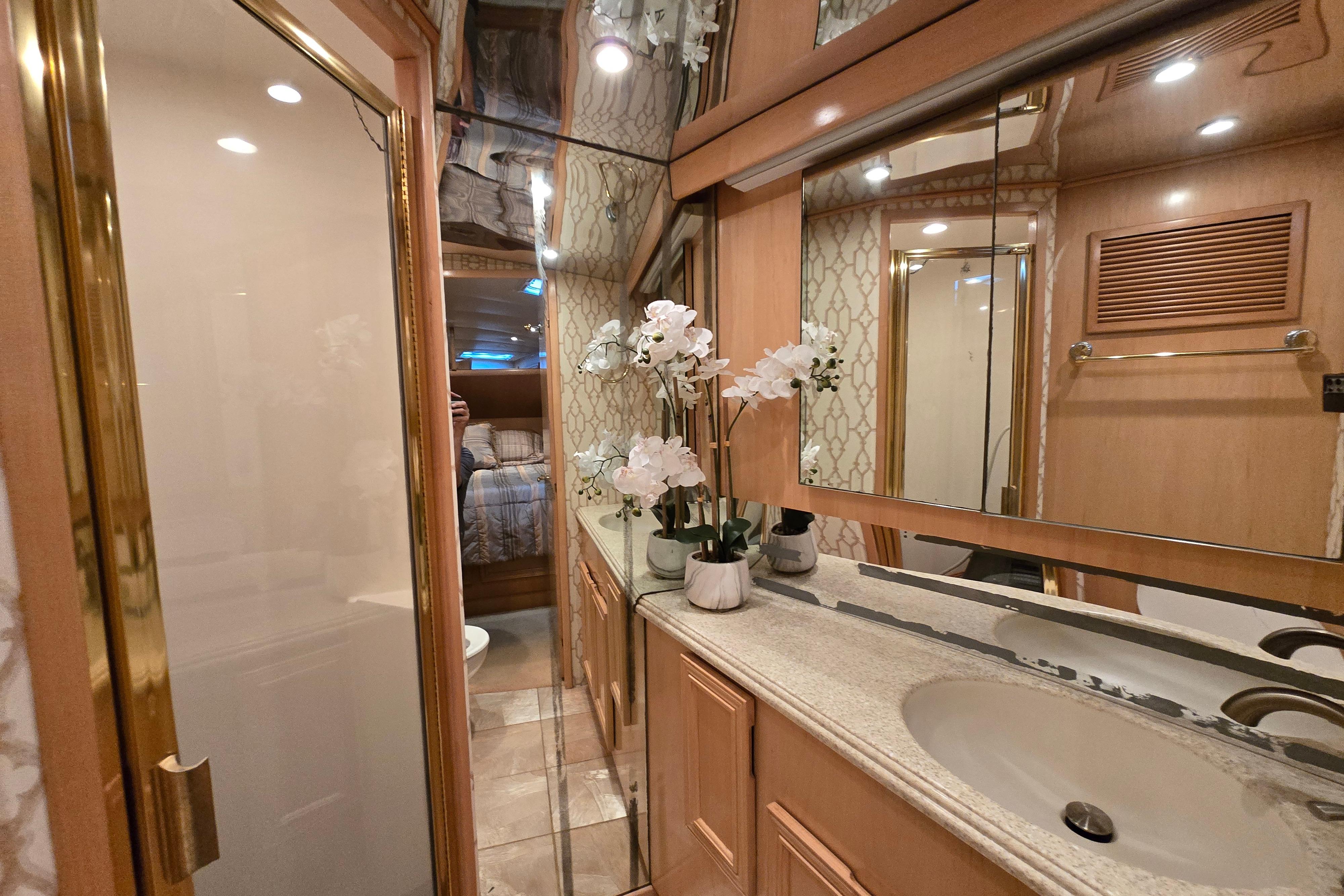 Luxurious bathroom in a 2001 Cavileer 53 Convertible yacht with elegant decor and floral accents.