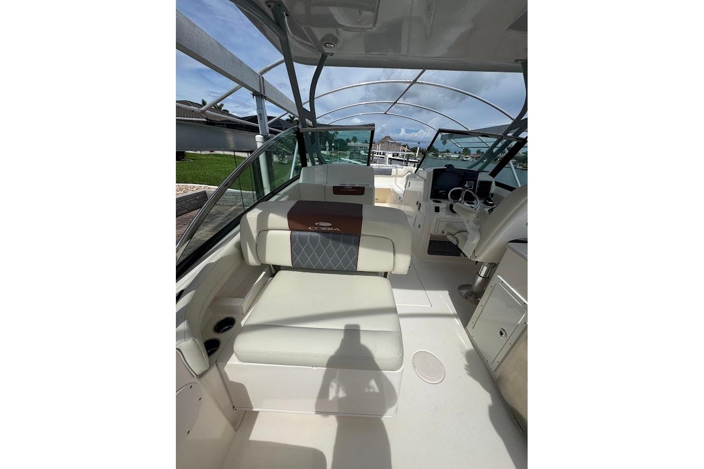 2020 Cobia 280 Dual Console boat interior with seating and helm, under clear skies.