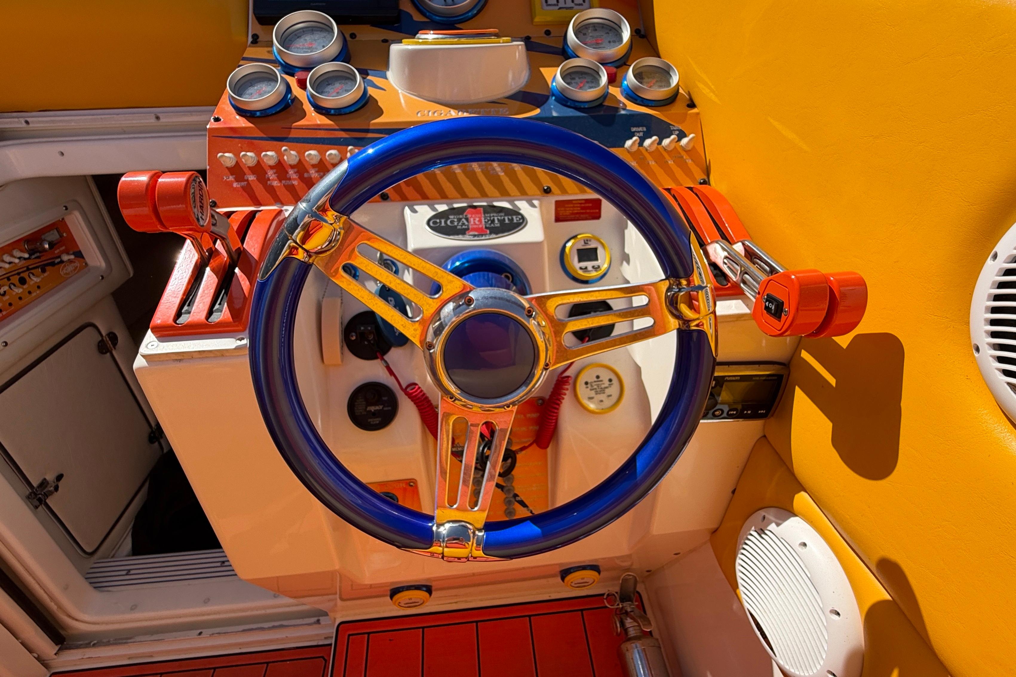 Colorful dashboard of a 2002 Cigarette 35' Cafe Racer boat with vibrant controls.