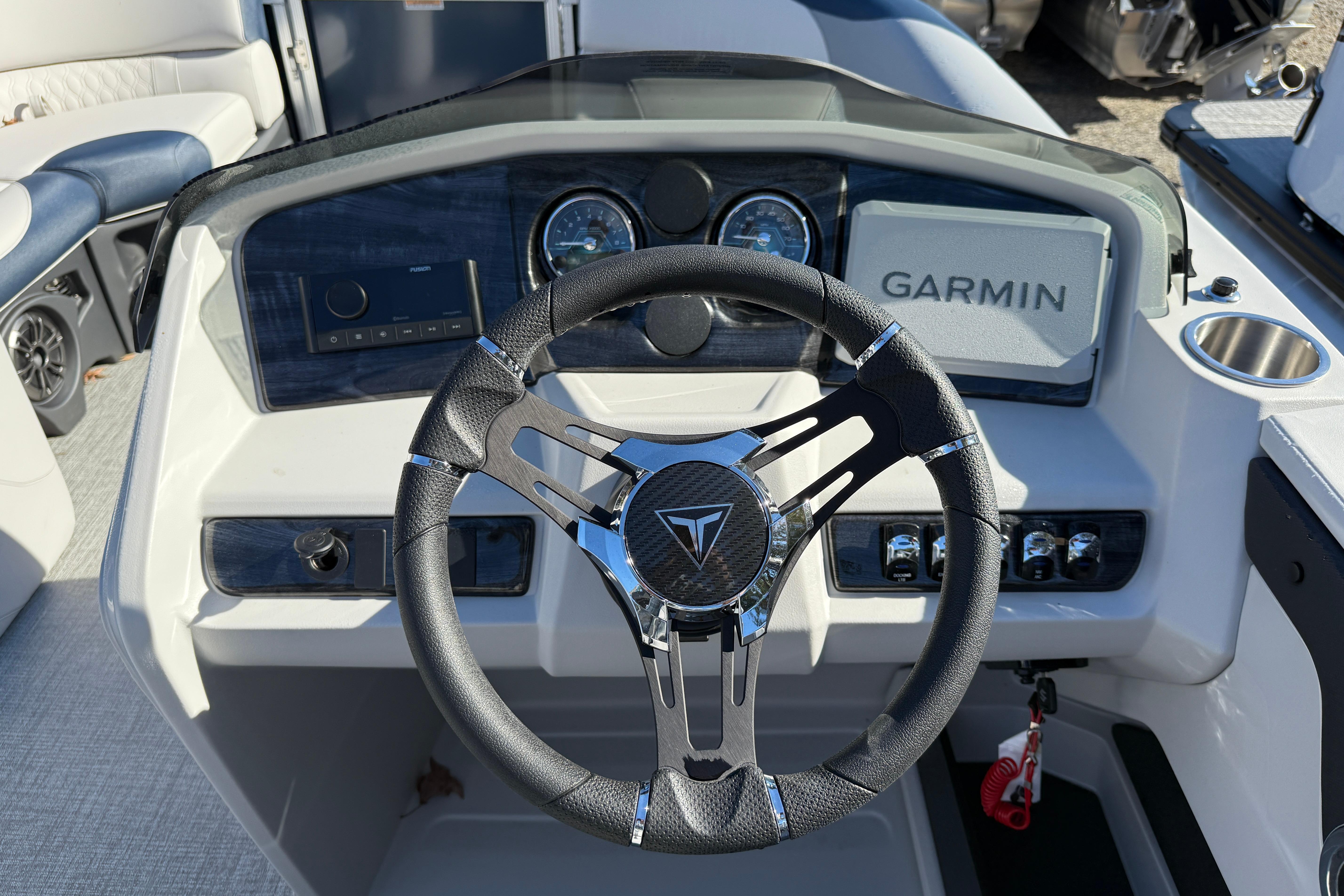 Steering wheel and dashboard of 2026 Tahoe Pontoon LTZ Quad Lounger with Garmin display.