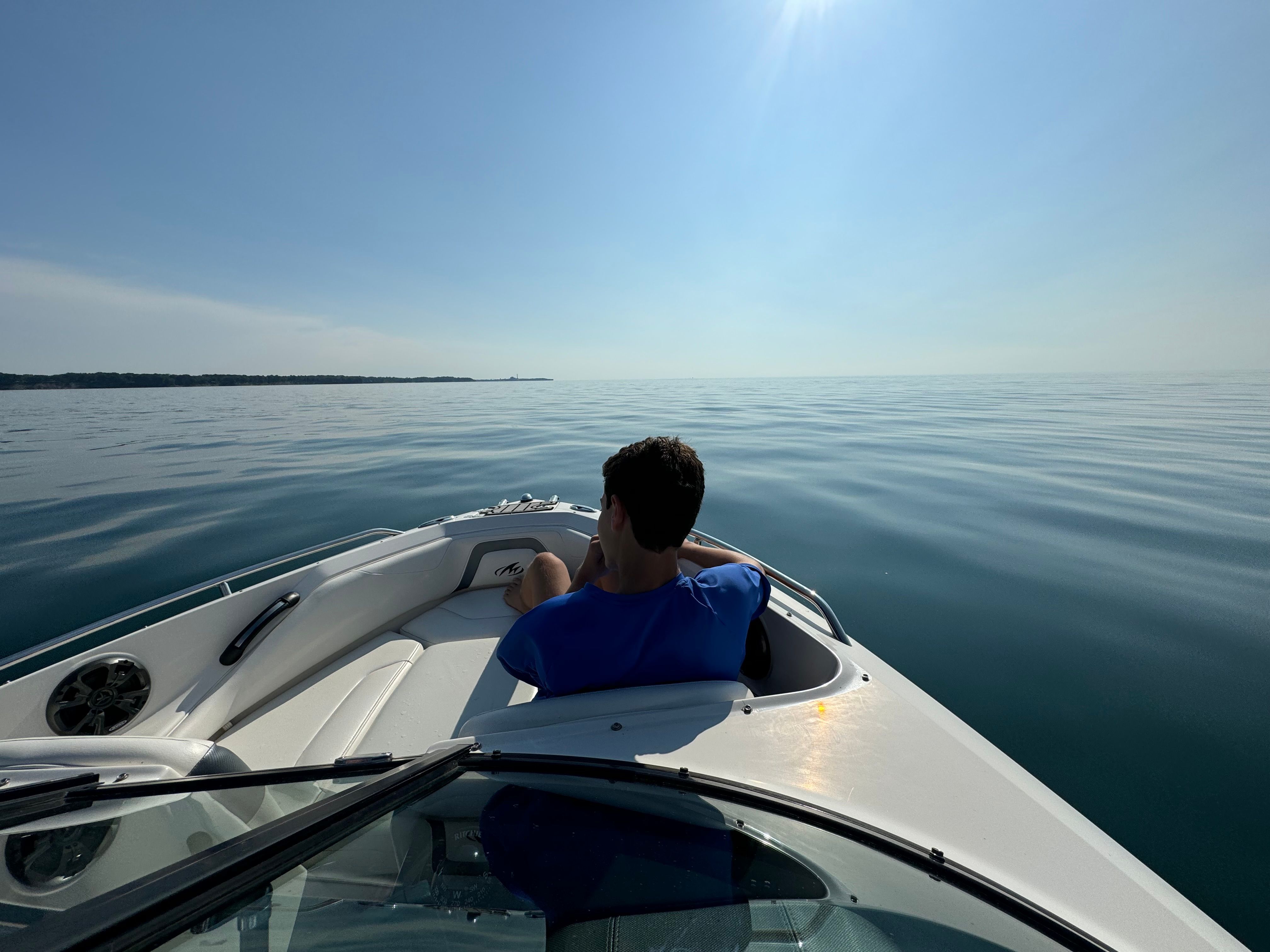 Person relaxing on Monterey 204FSX boat on calm water.
