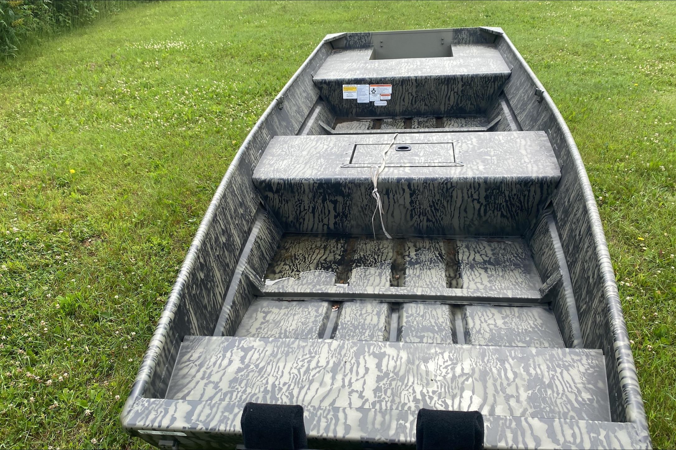 2026 Tracker Grizzly 15 Jon boat on grass, showcasing interior design and camo pattern.