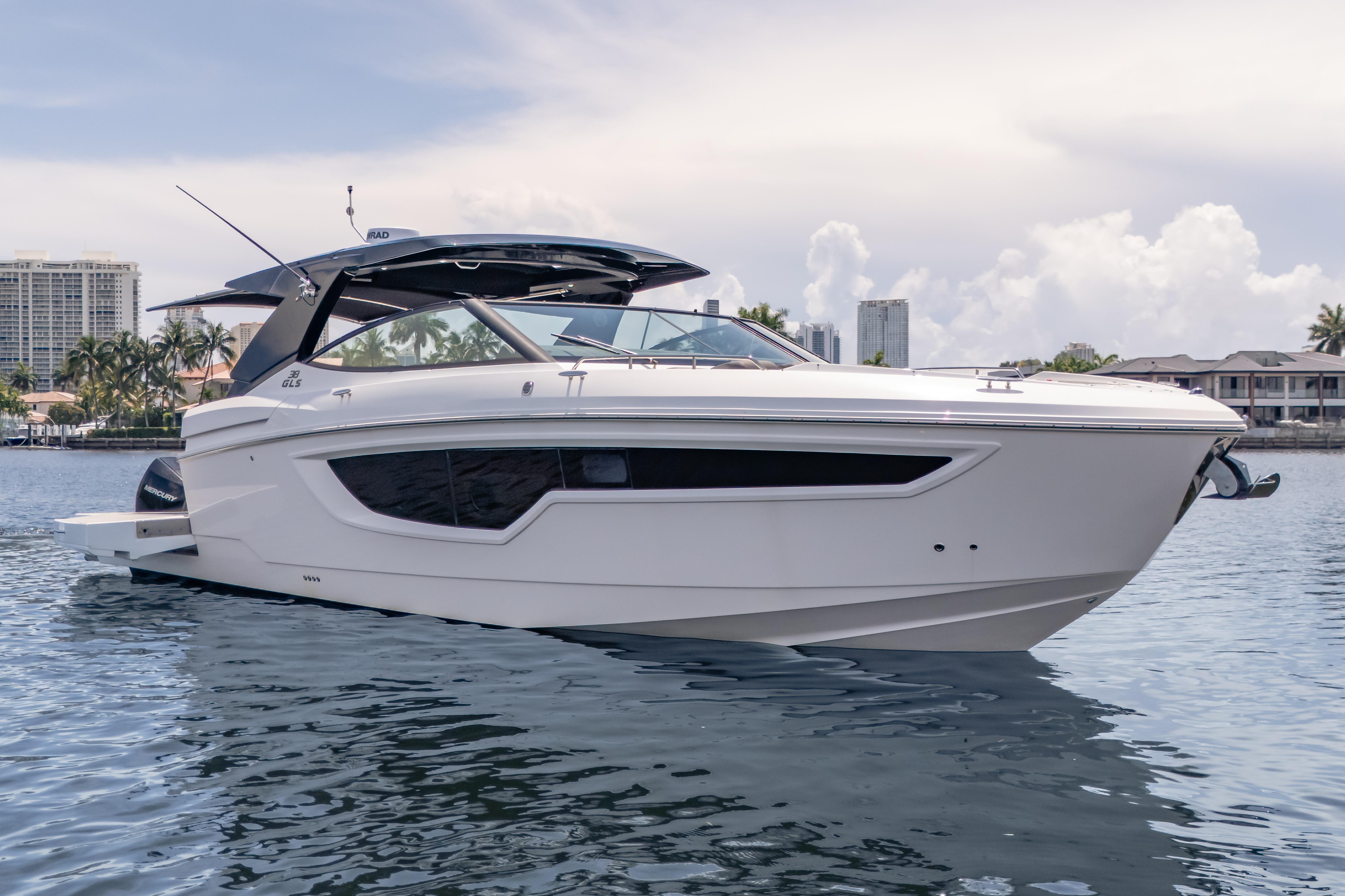2021 Cruisers Yachts 38 GLS luxury boat on calm water, cityscape background.