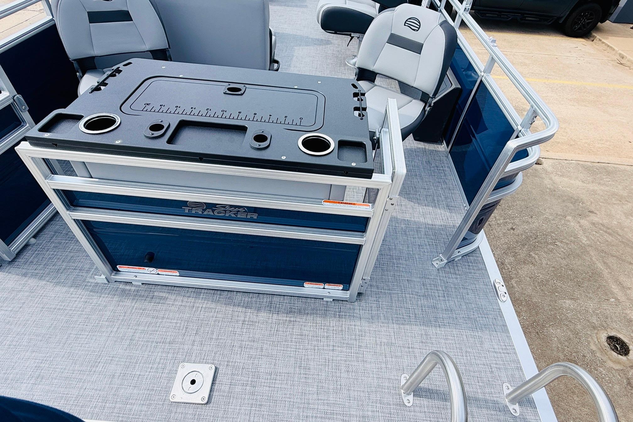 2026 Sun Tracker SportFish 22 DLX pontoon boat interior with seating and fishing station.