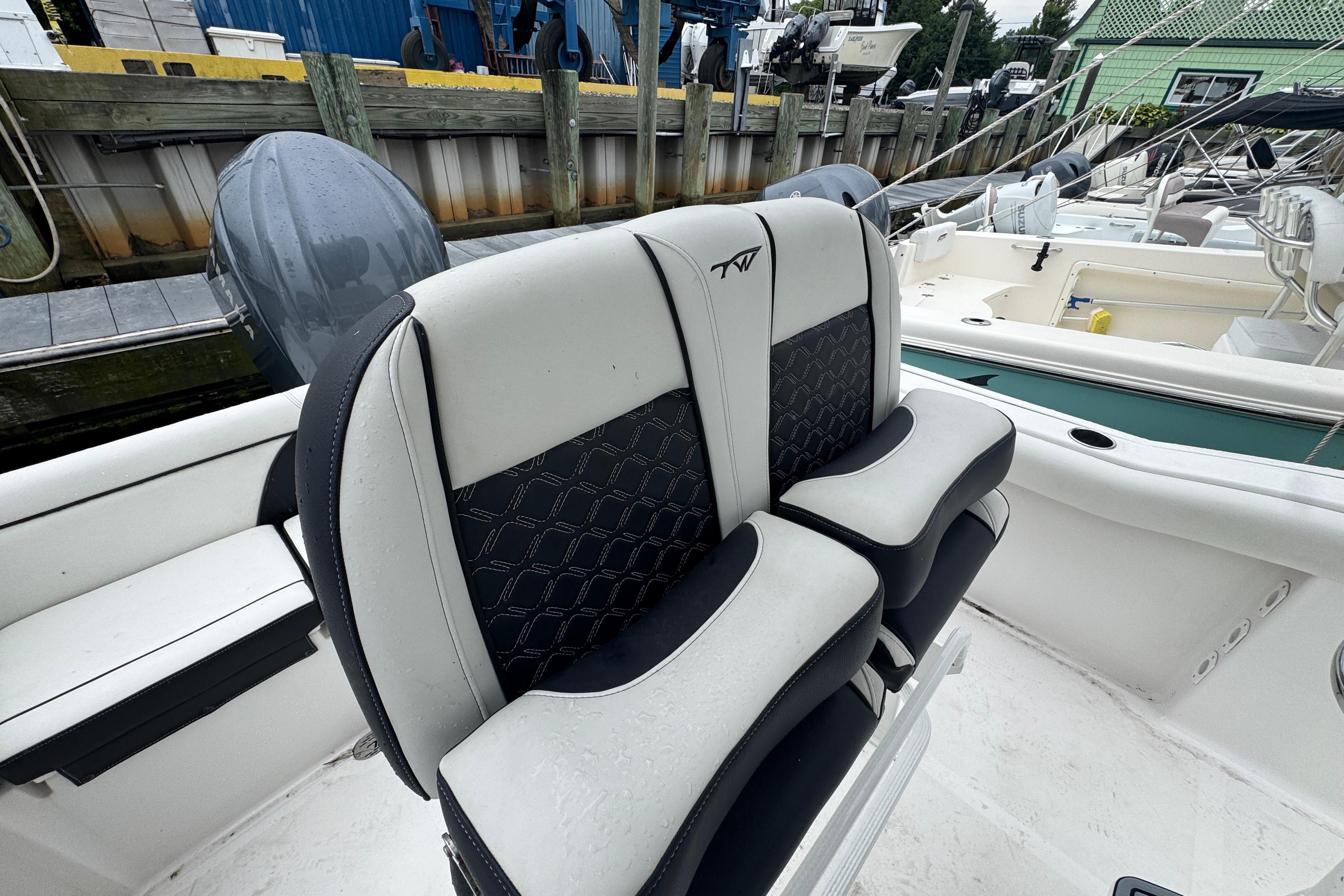 2022 Tidewater 232 SS boat with dual cushioned seats at a marina.
