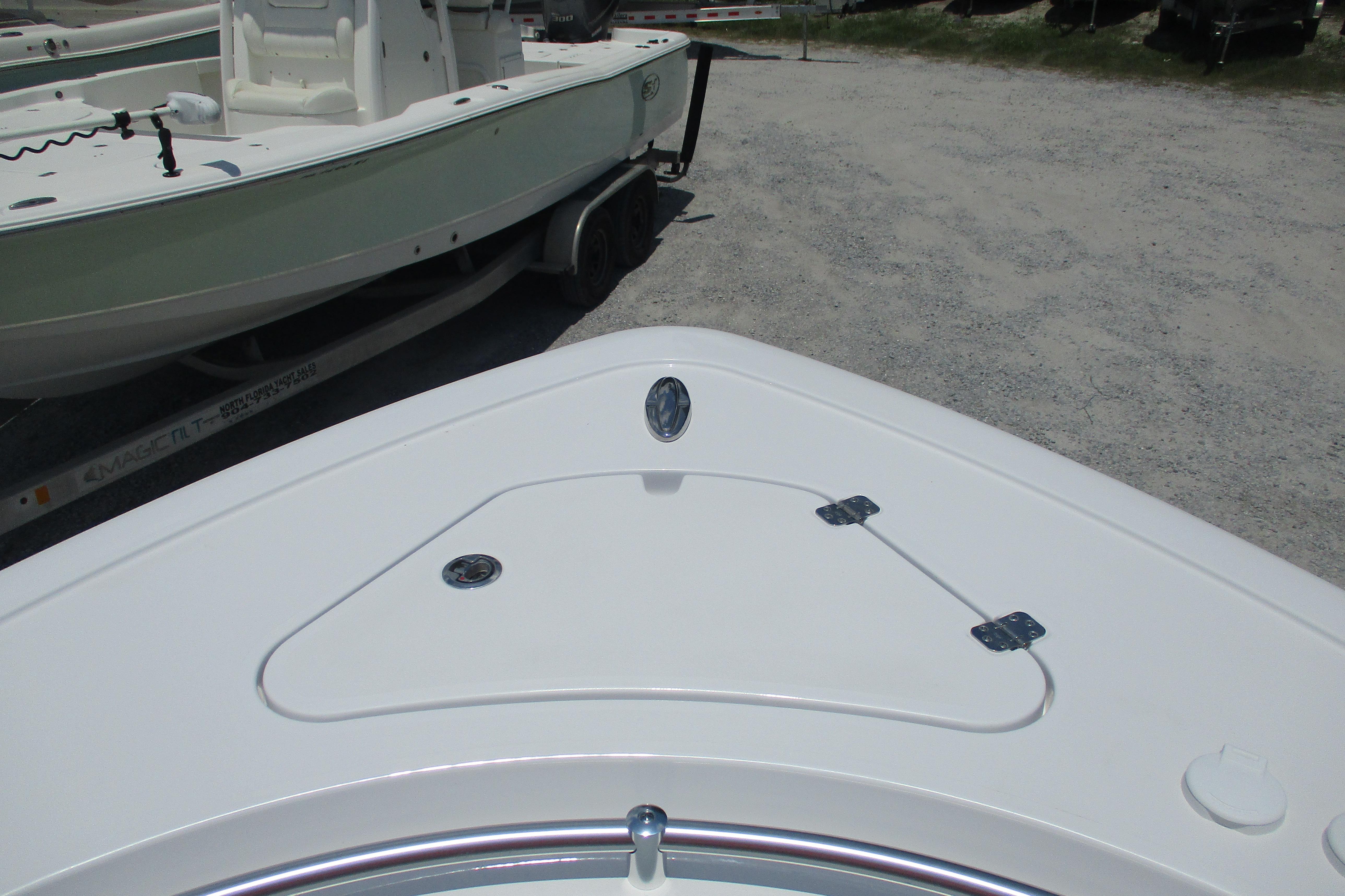 2027 Sportsman Open 252 Center Console boat on trailer, parked on gravel.