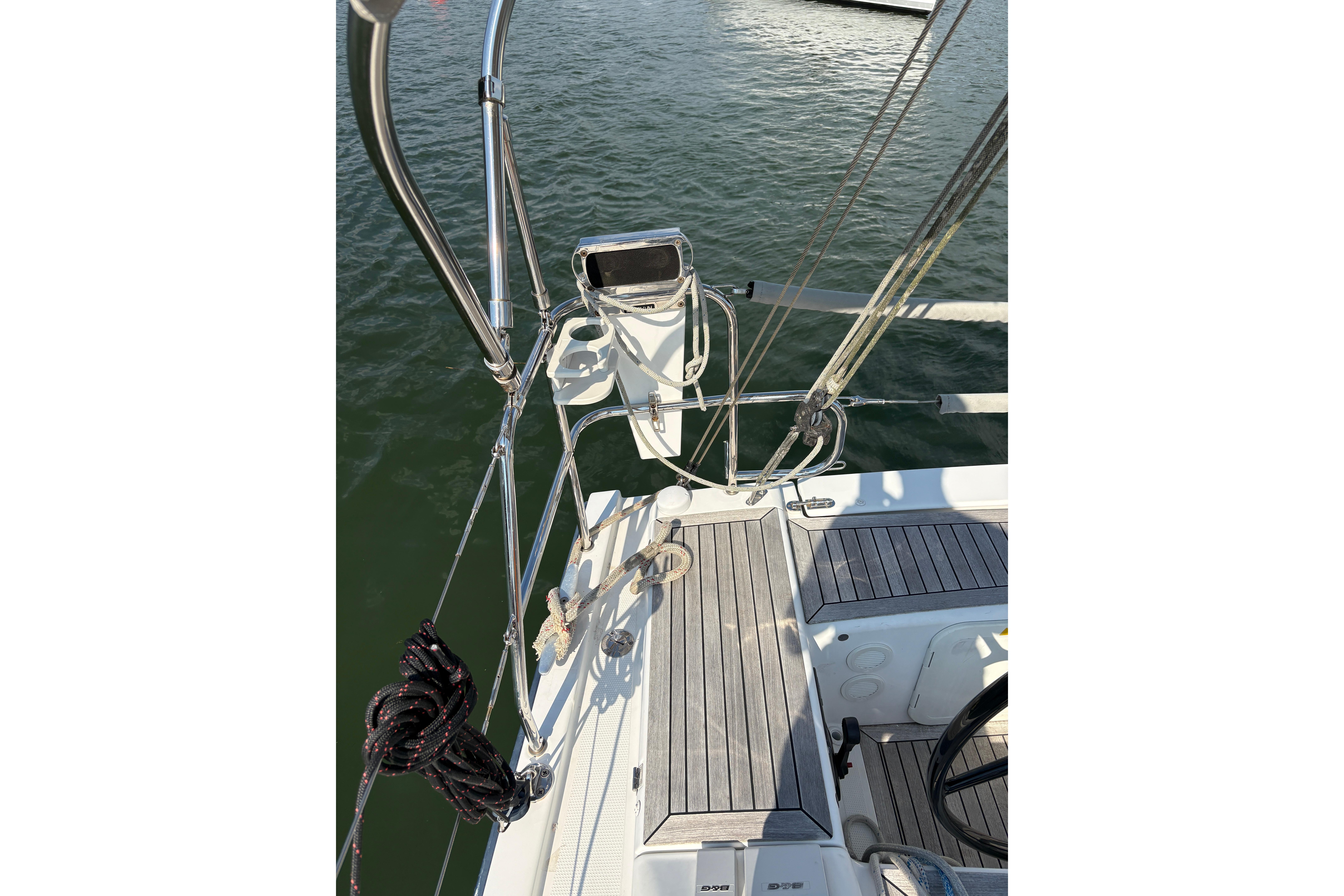 2014 Hanse 415 sailboat deck with ropes and steering wheel, docked on calm water.