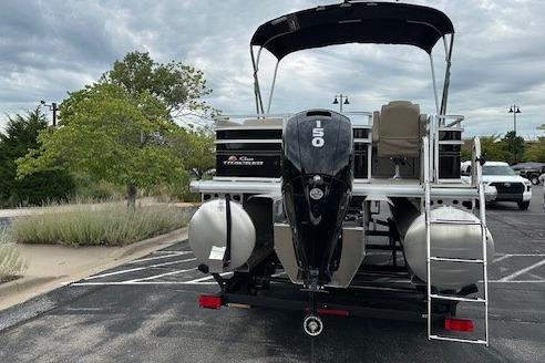 2025 Sun Tracker Sportfish 24 XP3 pontoon boat with 150 HP engine in parking lot.