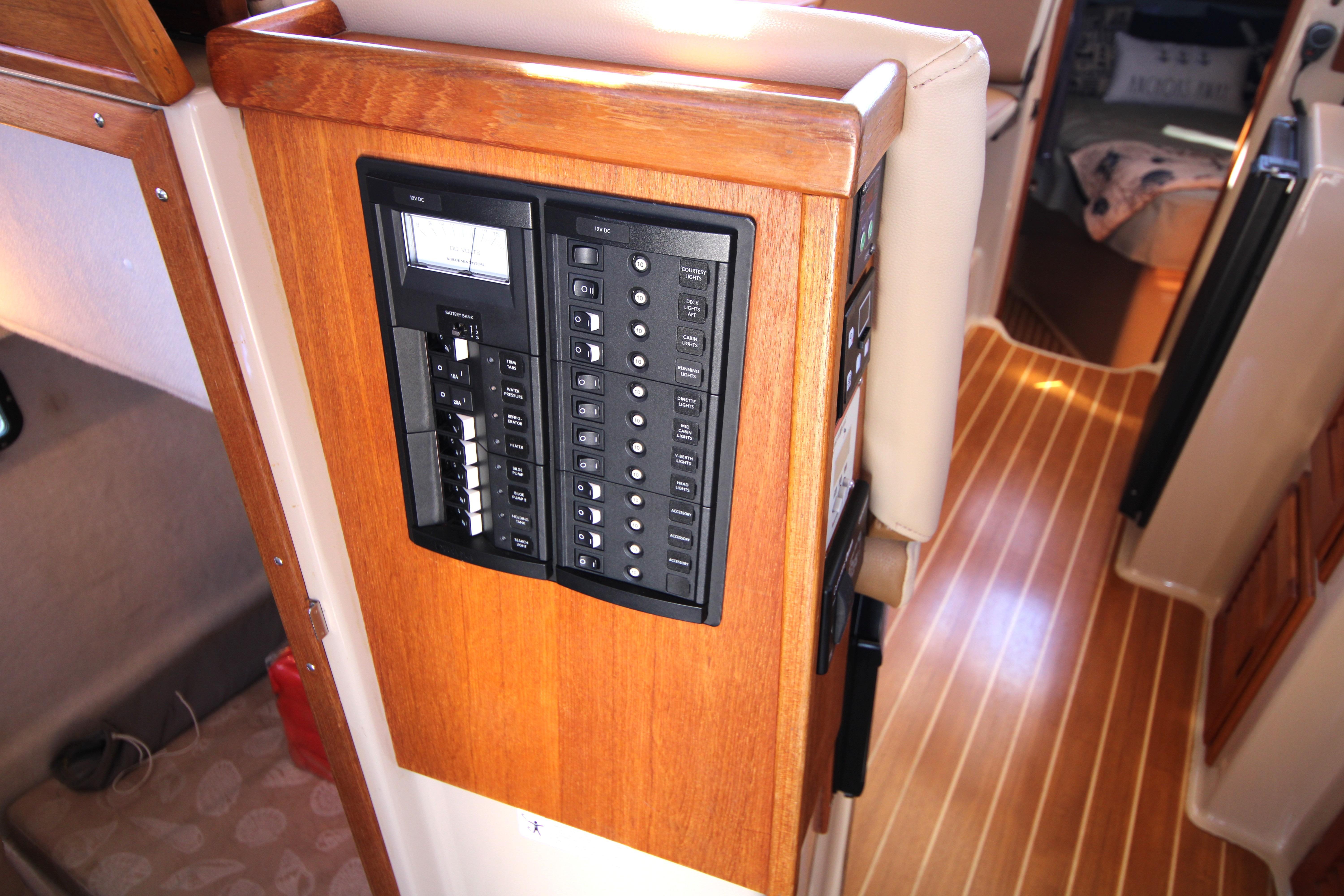 Electrical panel inside 2013 Ranger Tugs R-31 CB boat, featuring wooden interior and striped flooring.