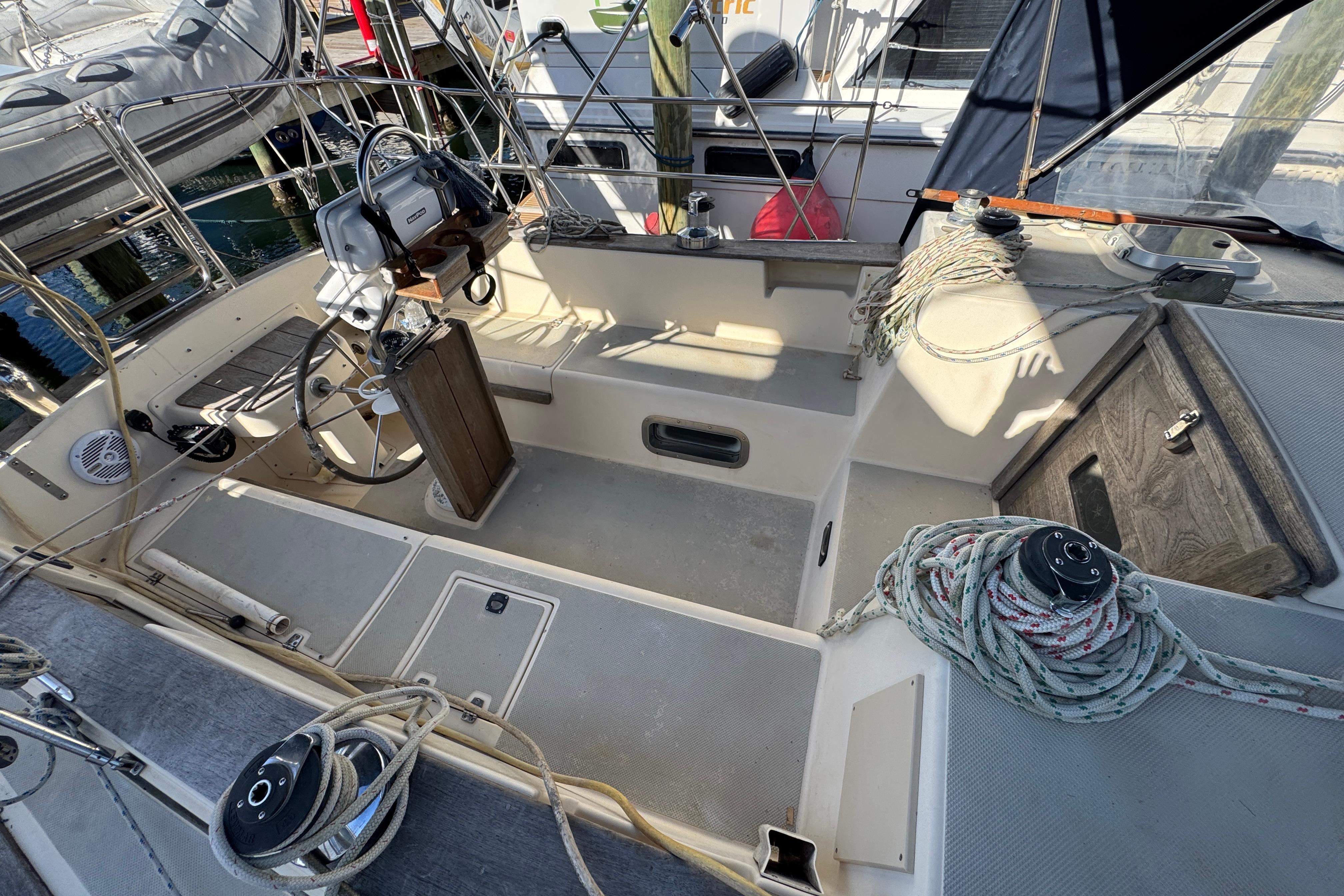 1991 Island Packet Yachts 38 cockpit with steering wheel and ropes, docked at marina.
