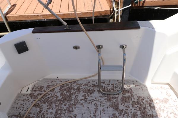 1992 Sea Ray 350 Express Bridge swim platform with ladder and dock in background.