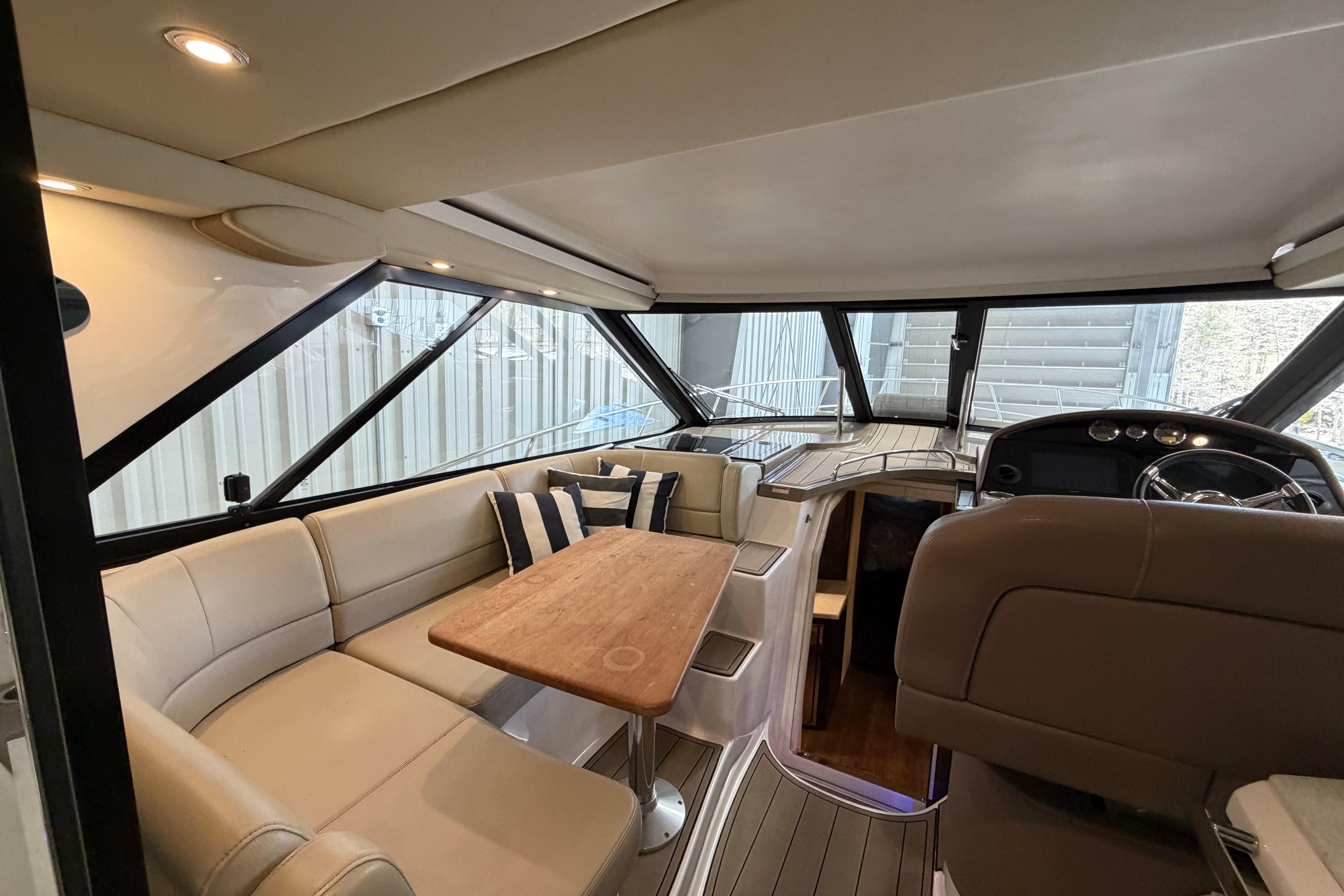 Interior of 2018 Regal 42 Sport Coupe yacht with elegant seating and wooden table.