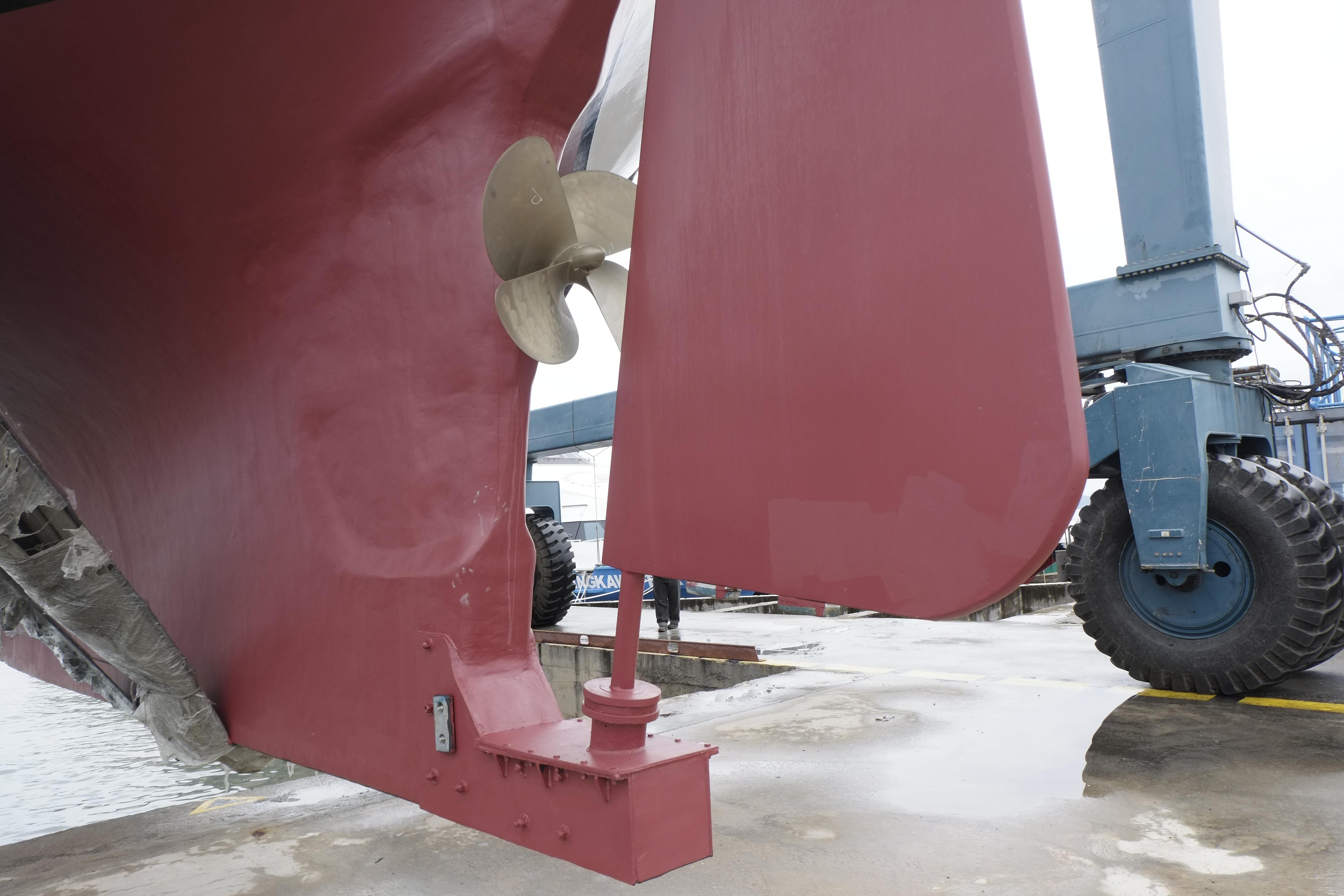 Close-up of a 2006 Custom Bud Macintosh schooner's rudder and propeller in a shipyard.