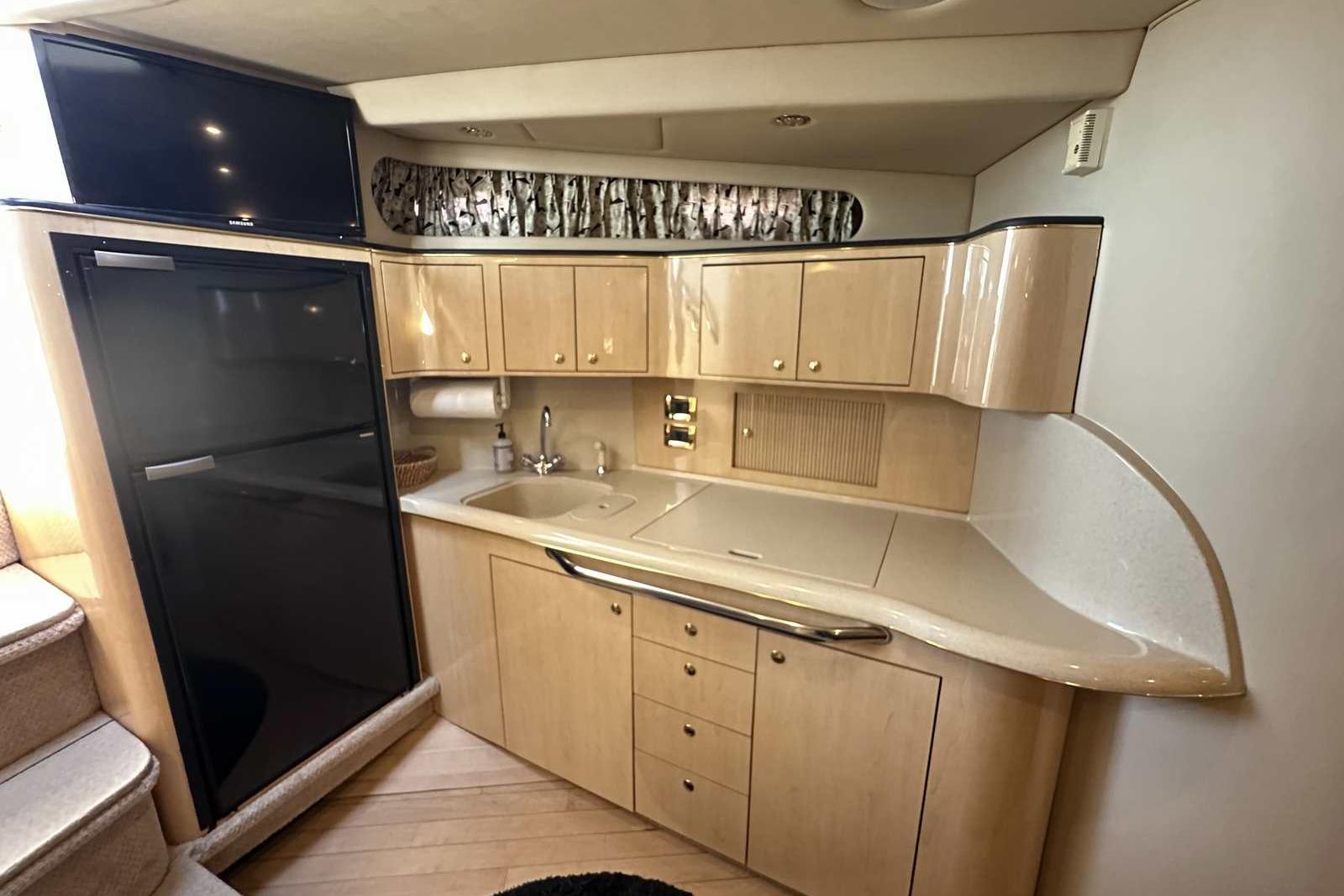 Interior of 2000 Sea Ray 410 Sundancer yacht with kitchenette and modern amenities.