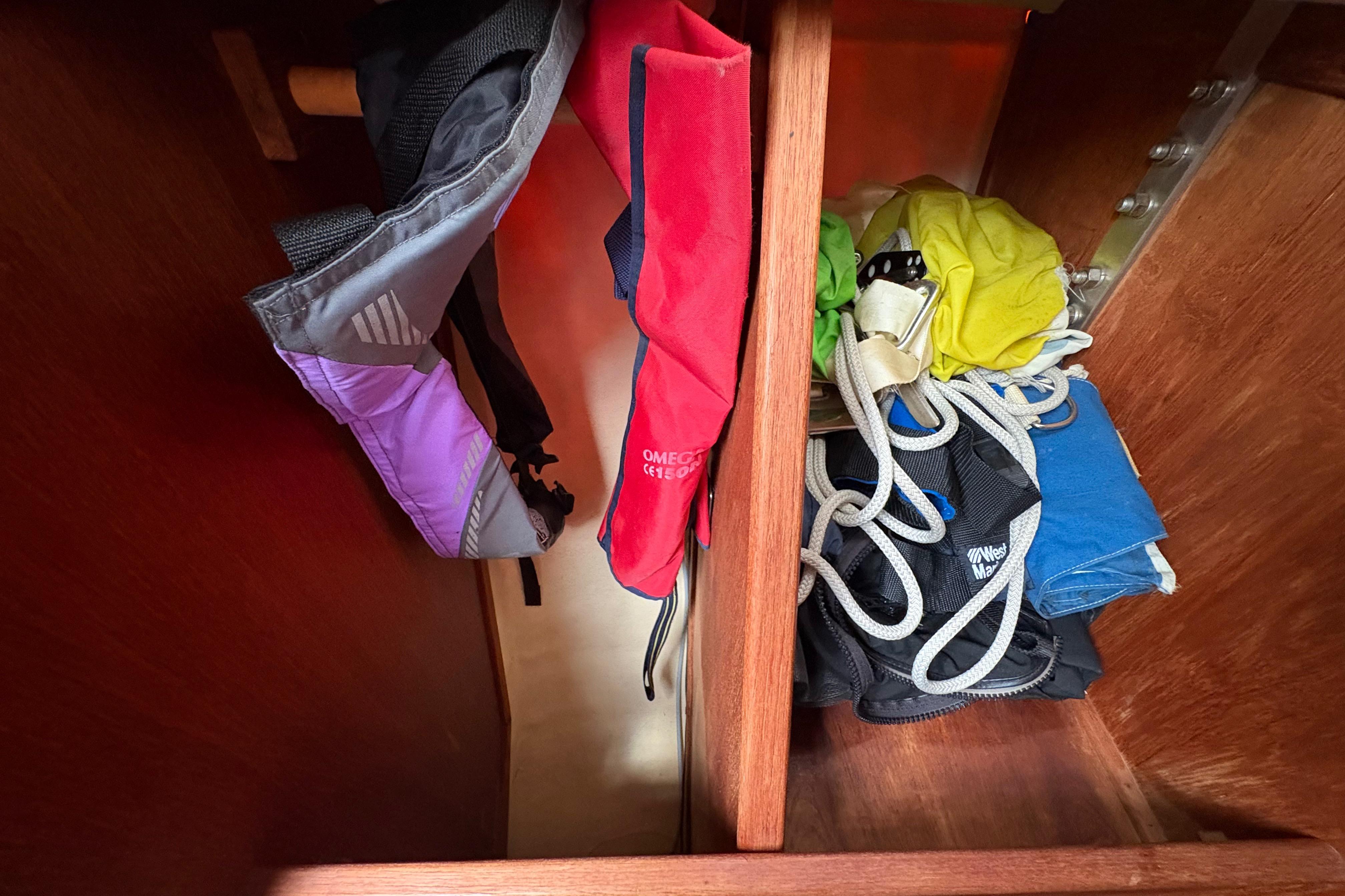 Storage compartment in 1981 Sabre 31 sailboat with life jackets and ropes.