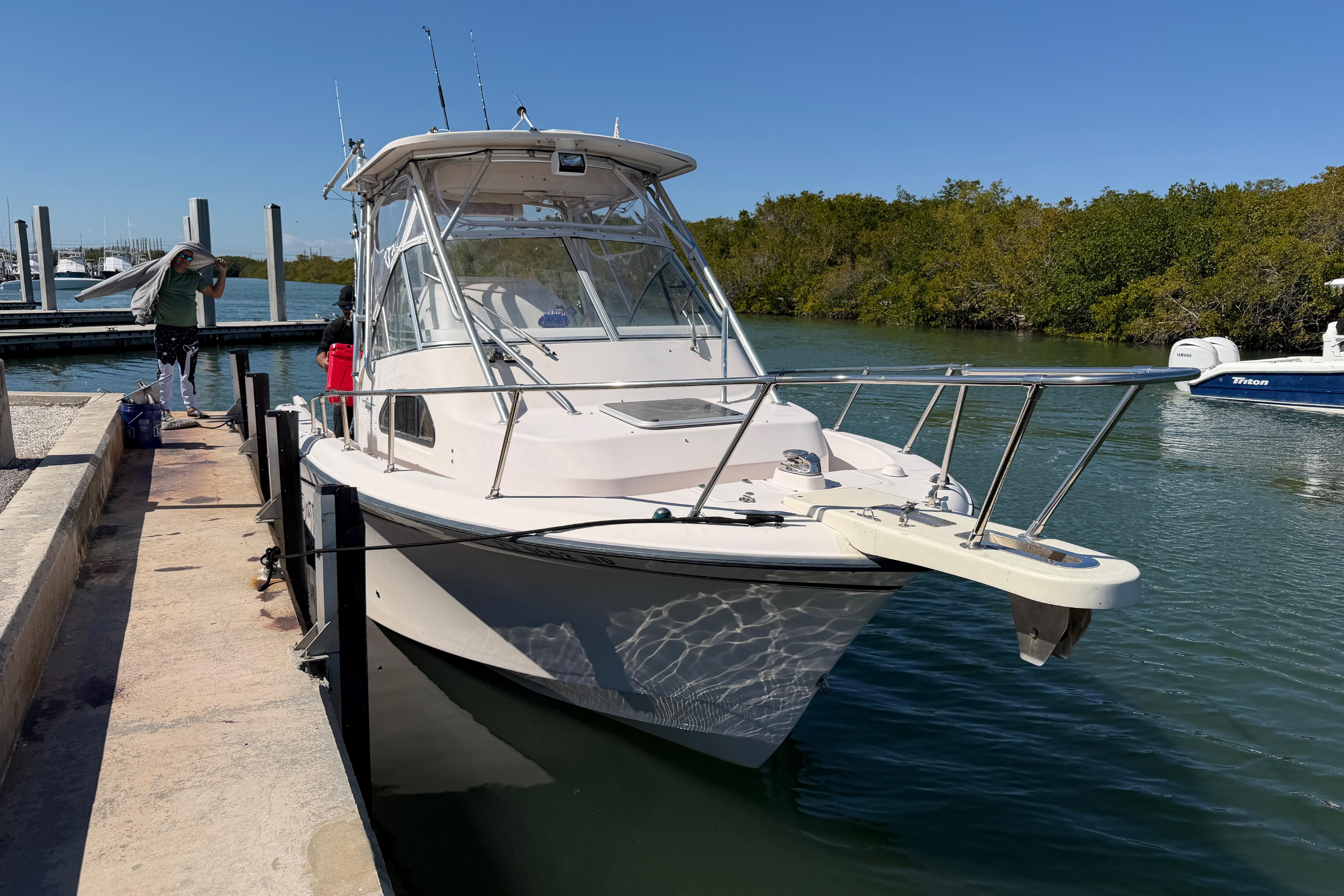 2006 Grady-White Sailfish 282 docked at marina, clear sky, calm water.