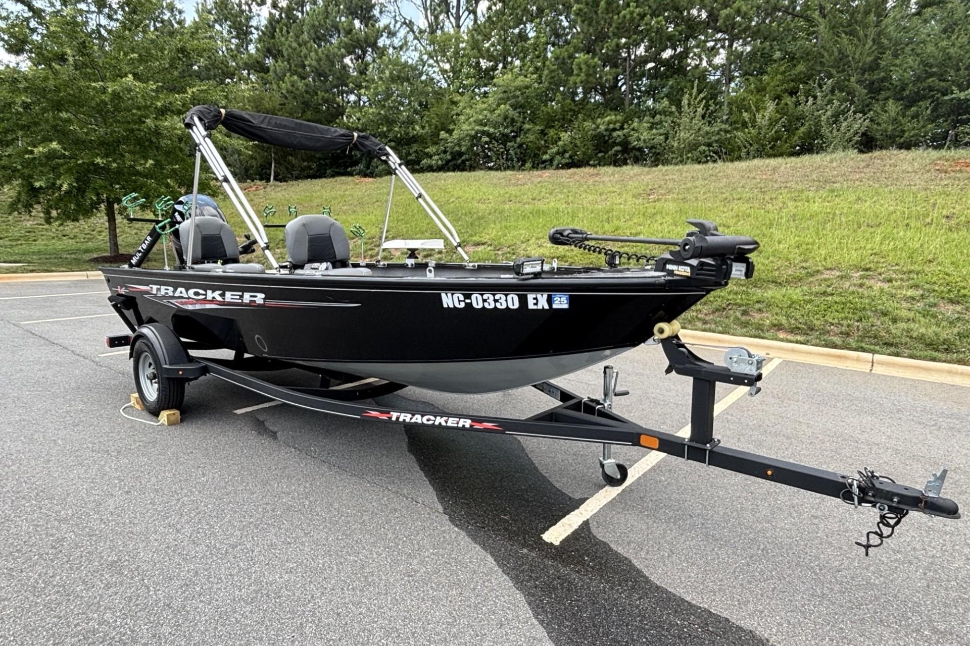 2022 Tracker Super Guide V-16 T boat on trailer, parked outdoors.