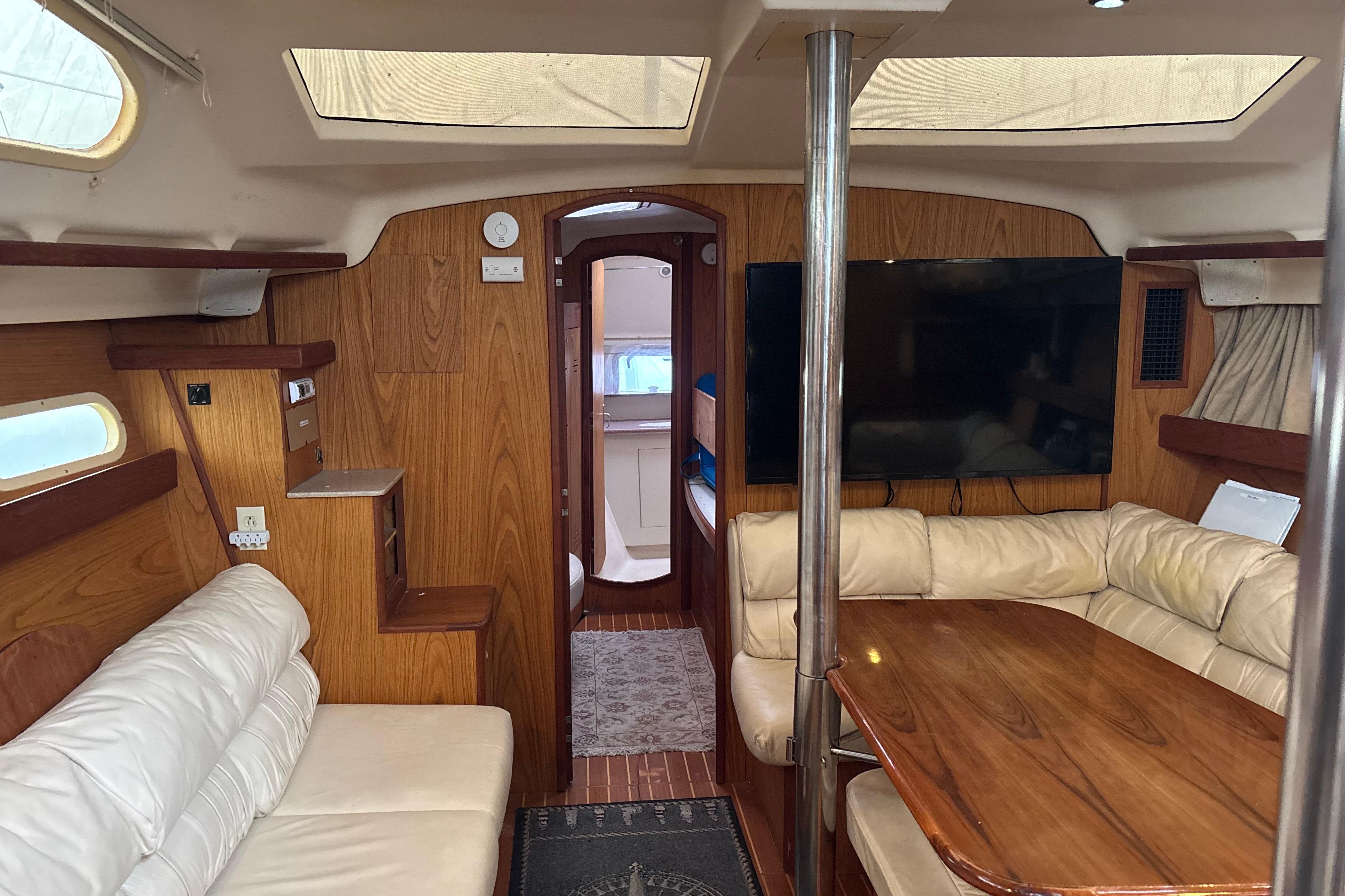 Interior of 2000 Hunter Passage 450 yacht with wood paneling and leather seating.