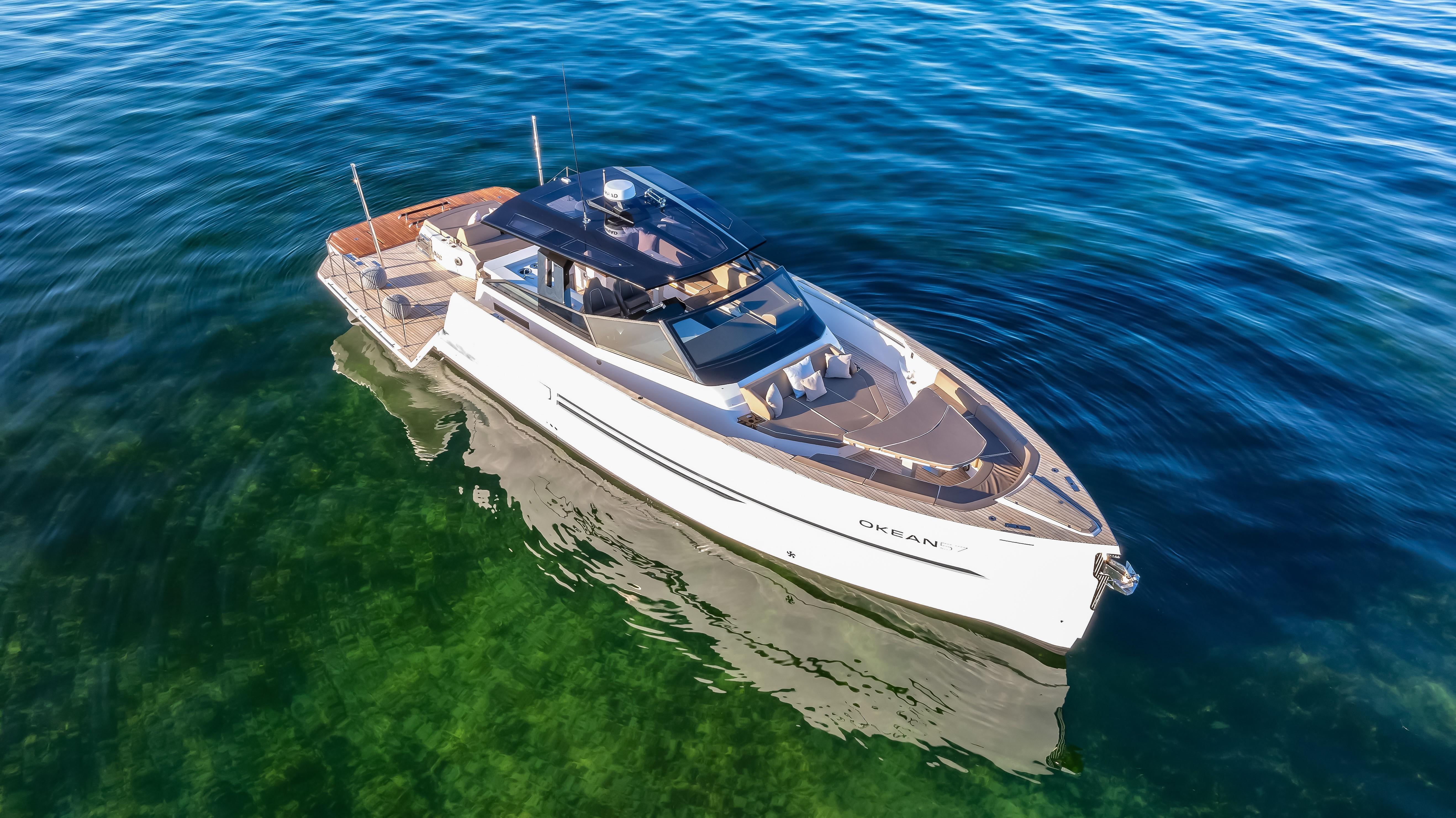 Luxury OKEAN 57 yacht cruising on clear blue water, 2026 model.