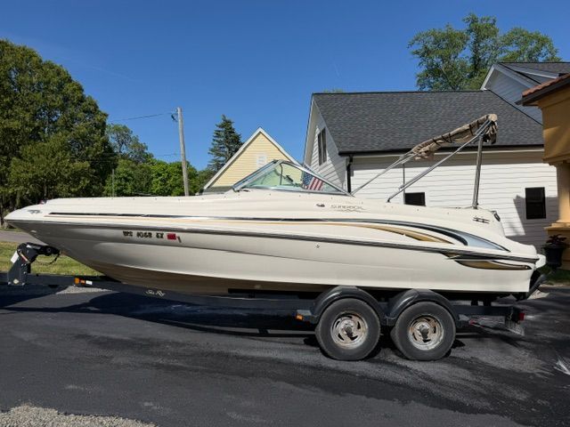 A 2001 Sea Ray 210 Sundeck boat on a trailer in a residential area.