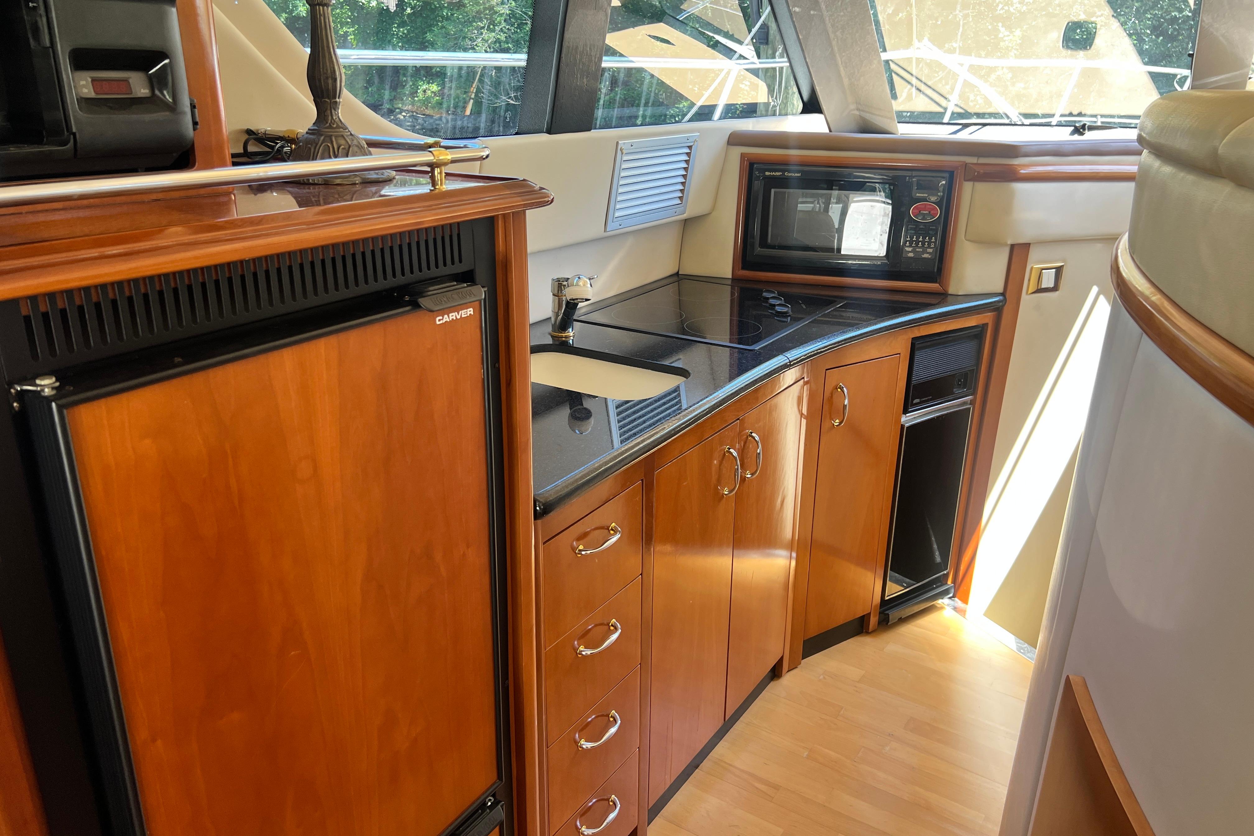 Luxurious kitchen interior of 2003 Carver 450 Voyager Pilothouse yacht with wood cabinetry.