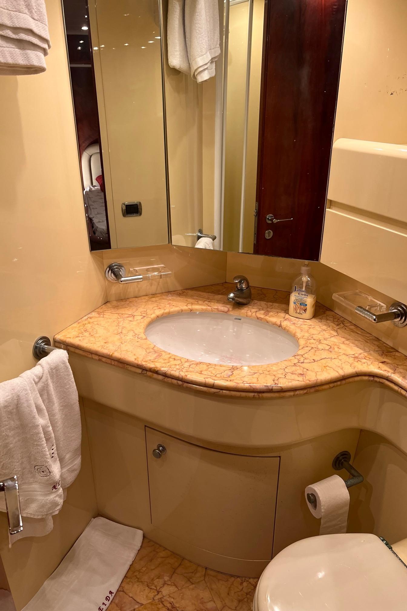 Luxurious bathroom in a 2001 Maiora 20 yacht with marble countertop and modern fixtures.