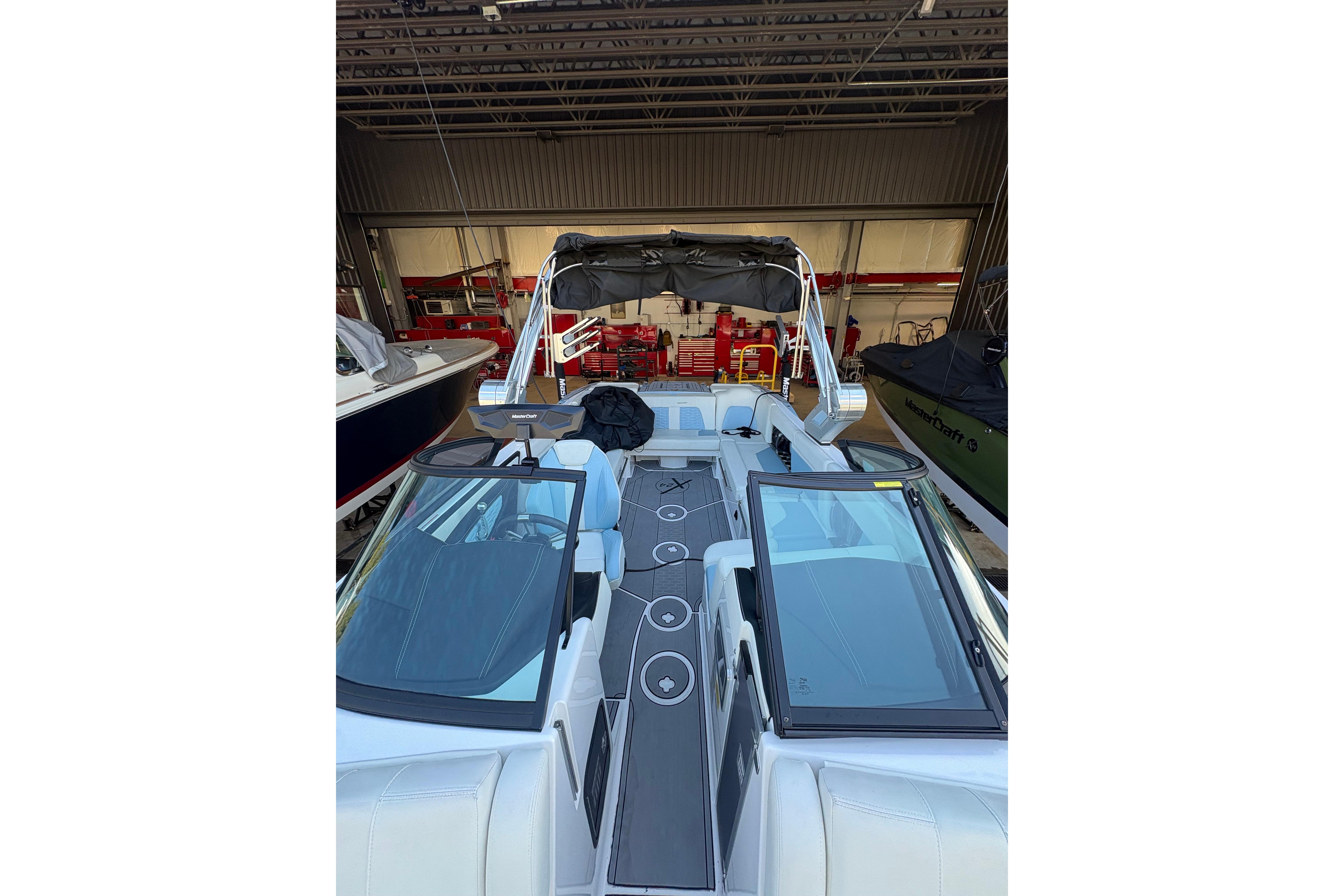 2022 MasterCraft X24 boat interior with sleek design and modern features in a garage setting.