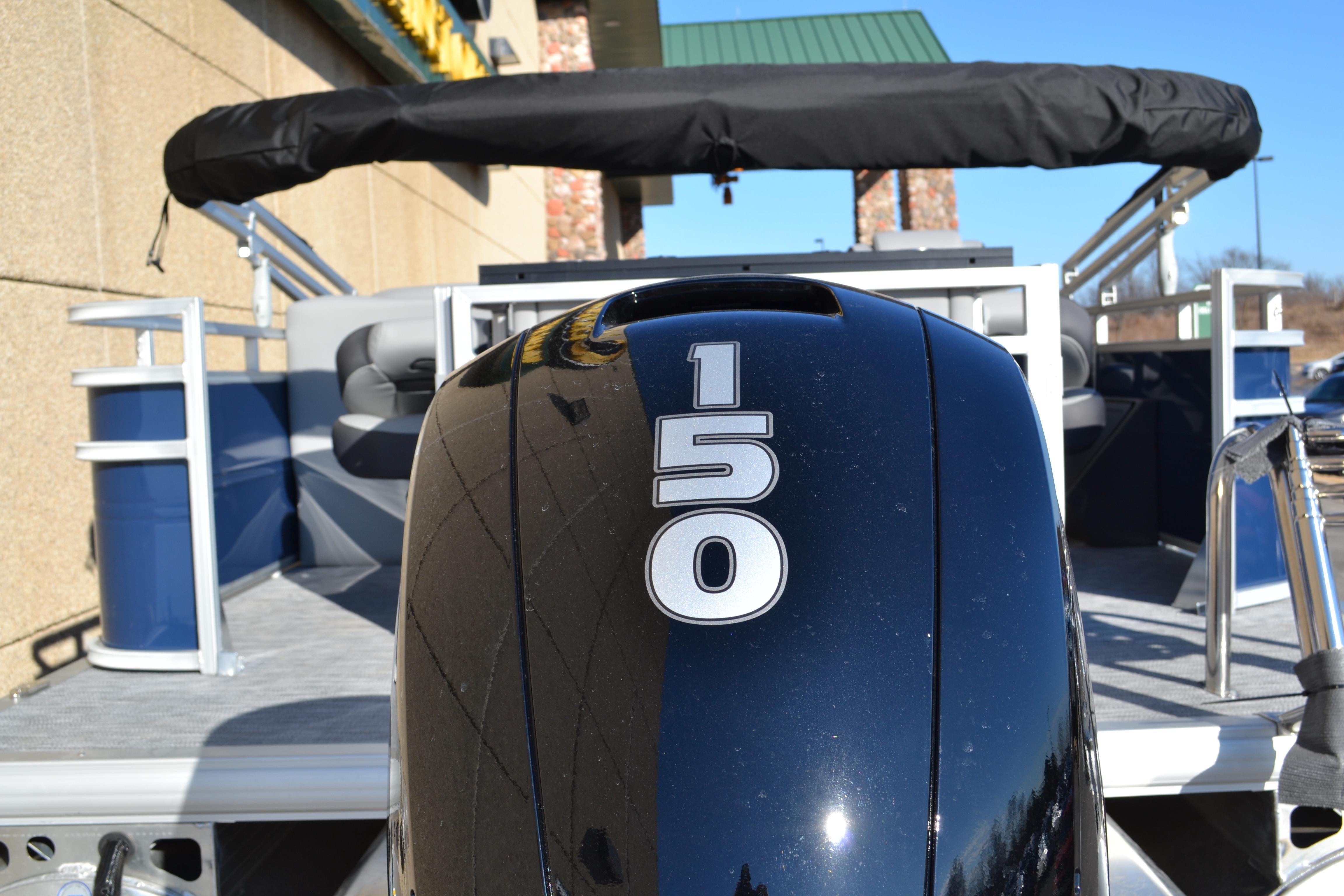 2026 Sun Tracker SportFish 22 XP3 boat with 150 horsepower engine, docked outdoors.