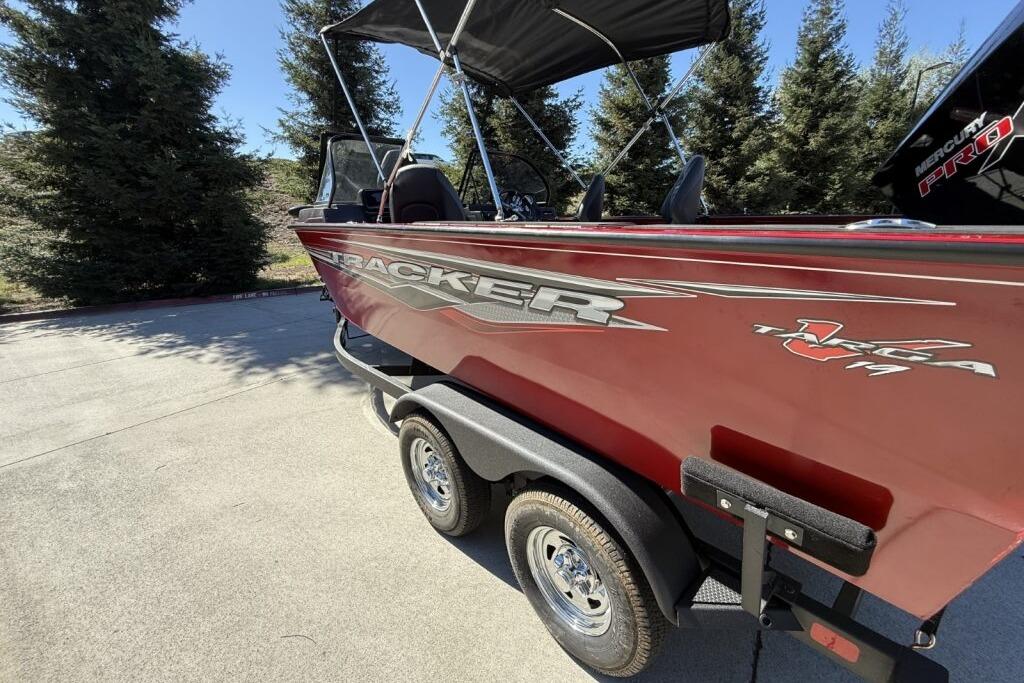 2024 Tracker Targa V-19 WT boat on trailer, parked outdoors, with trees in the background.