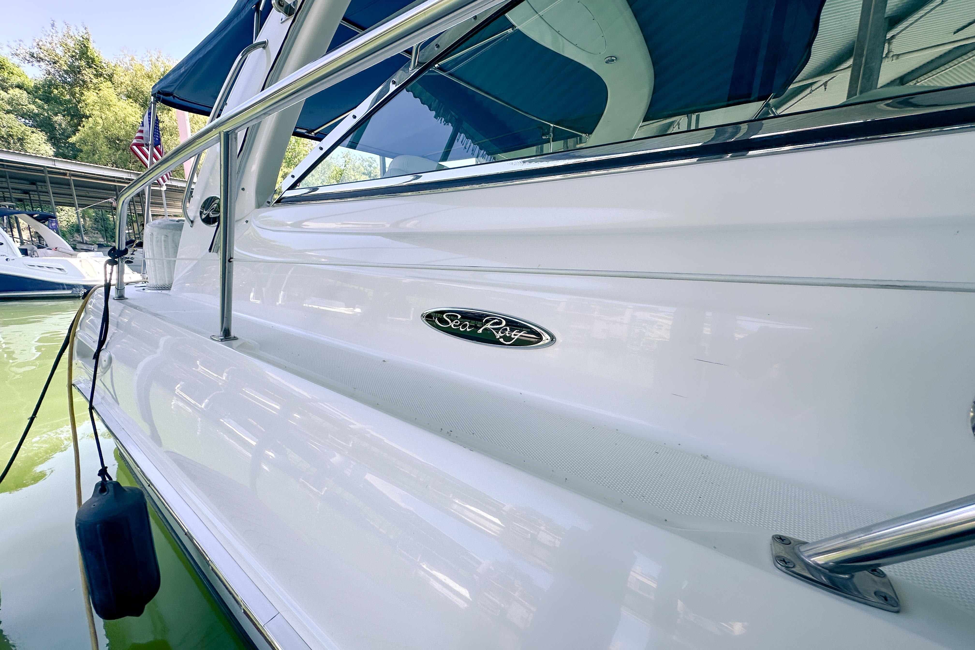 2001 Sea Ray 410 Sundancer yacht docked, showcasing sleek white exterior and logo.
