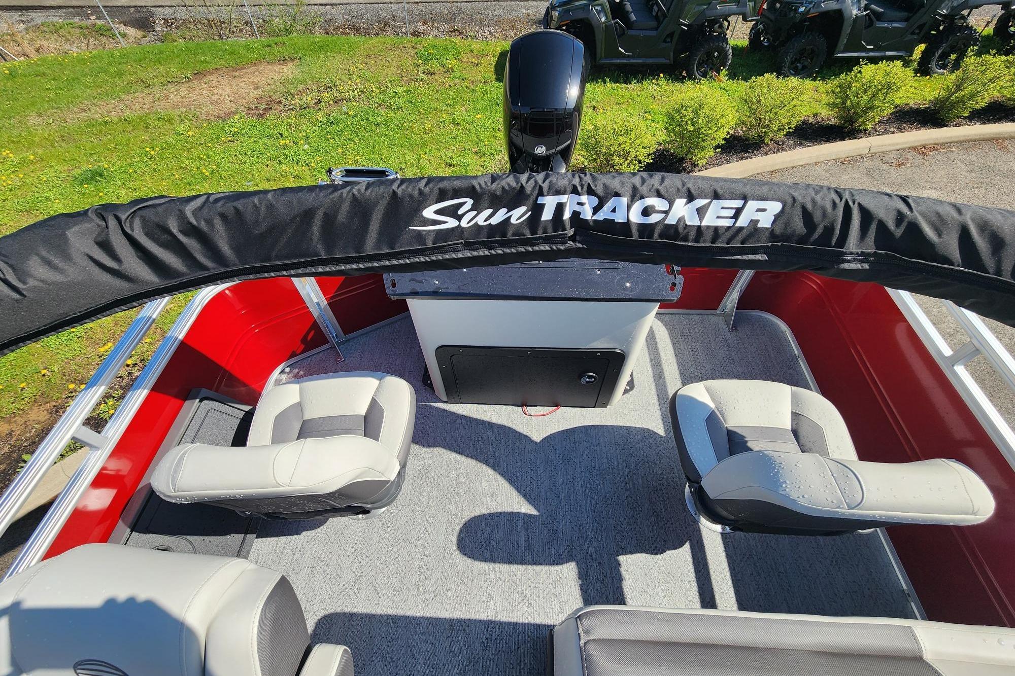 2026 Sun Tracker Fishin' Barge 22 DLX interior with seating and protective cover.