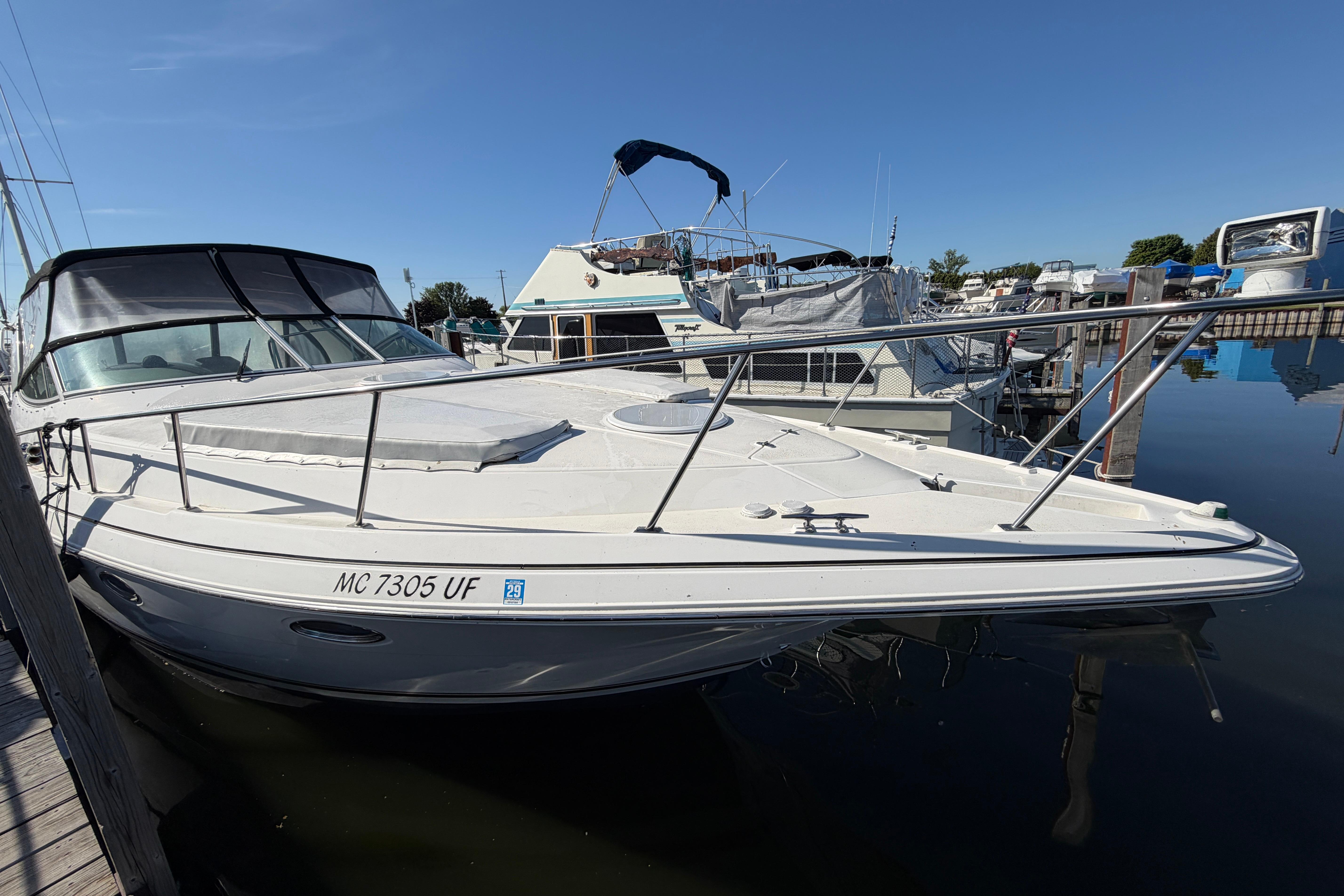 2004 Cruisers Yachts 3372 Express docked at marina under clear blue sky.